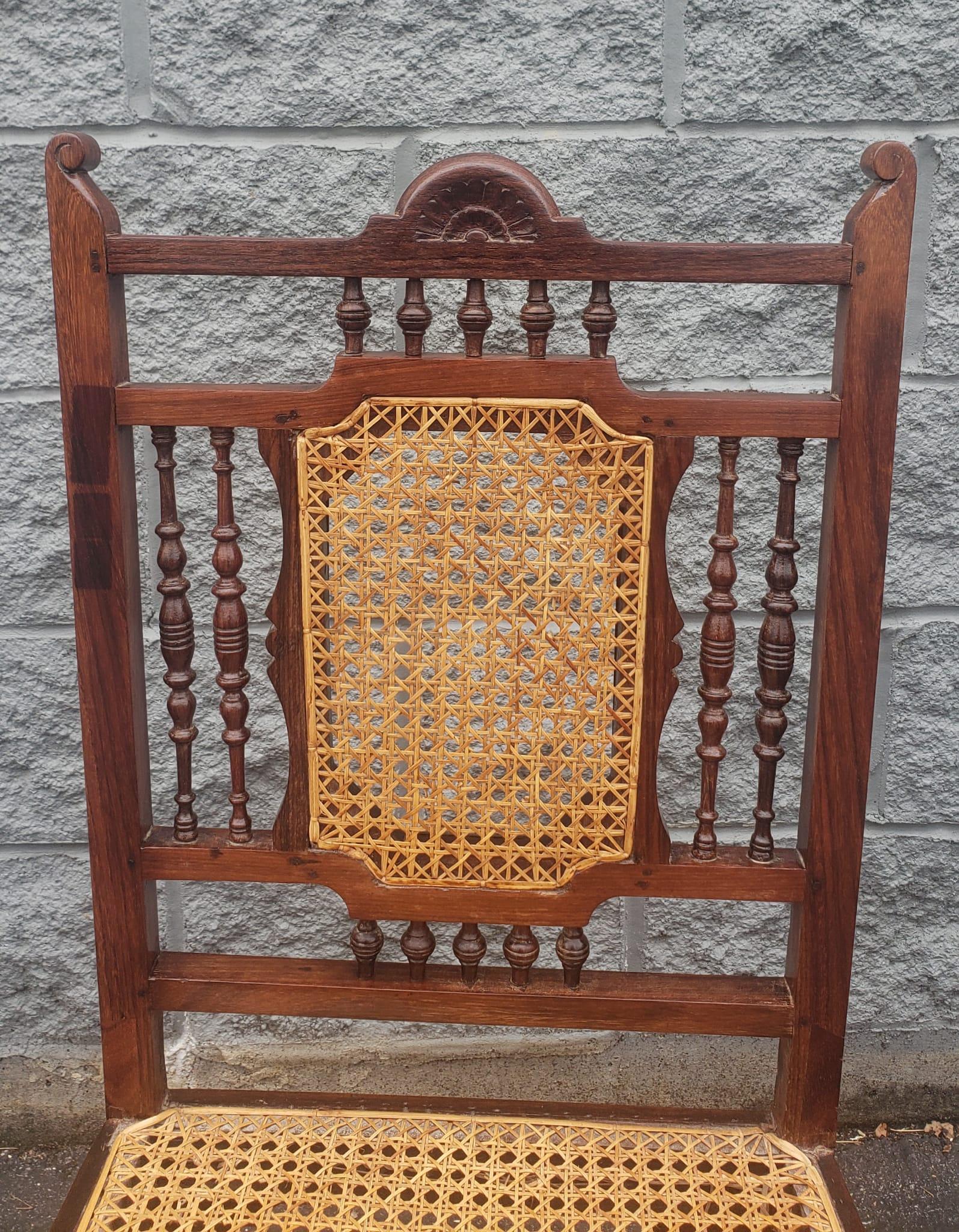 An exquisite pair of Anglo-Indian hardwood and rosewood cane seat and back handcrafted side chairs. Newer caning in great condition. Mini spindles decorated on all sides and front.