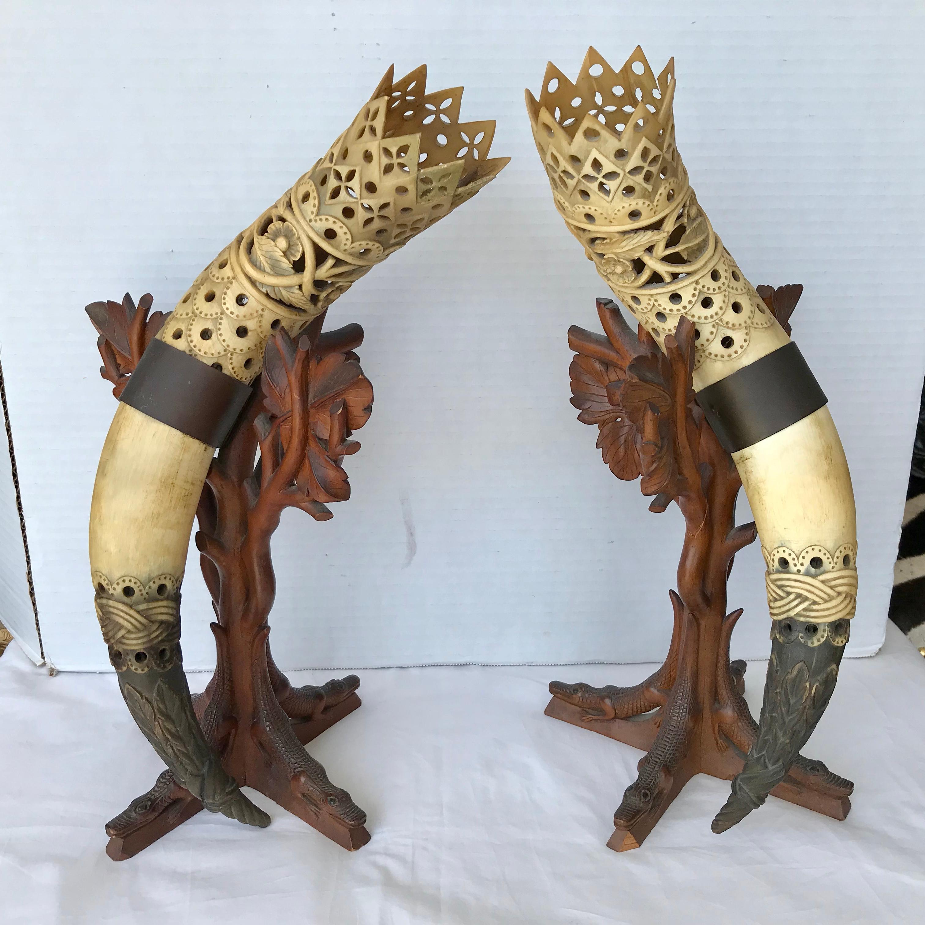The horns are elaborately carved and mounted in carved wood stands
which terminate with figures of crocodiles.
A rare and unusual pair.