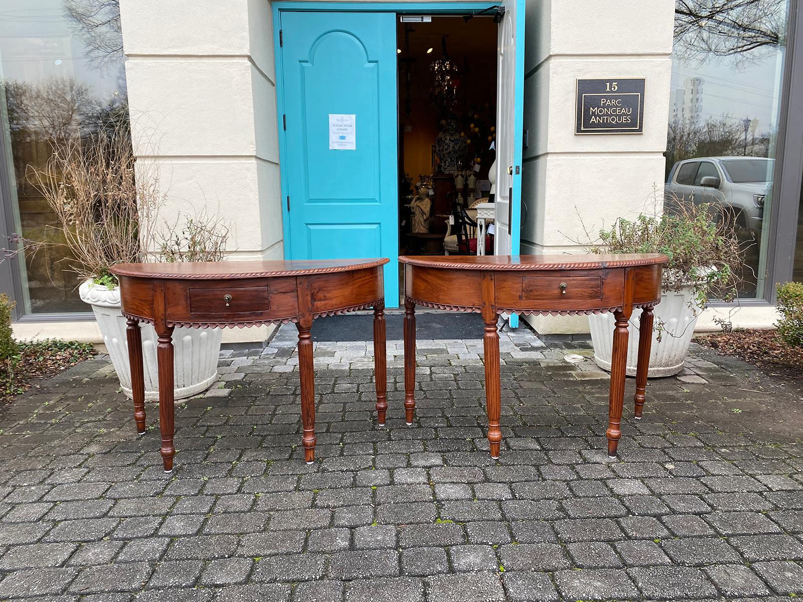 Pair of 19th-20th century Anglo-Indian or Anglo-Caribbean carved demilune console tables, one drawer.