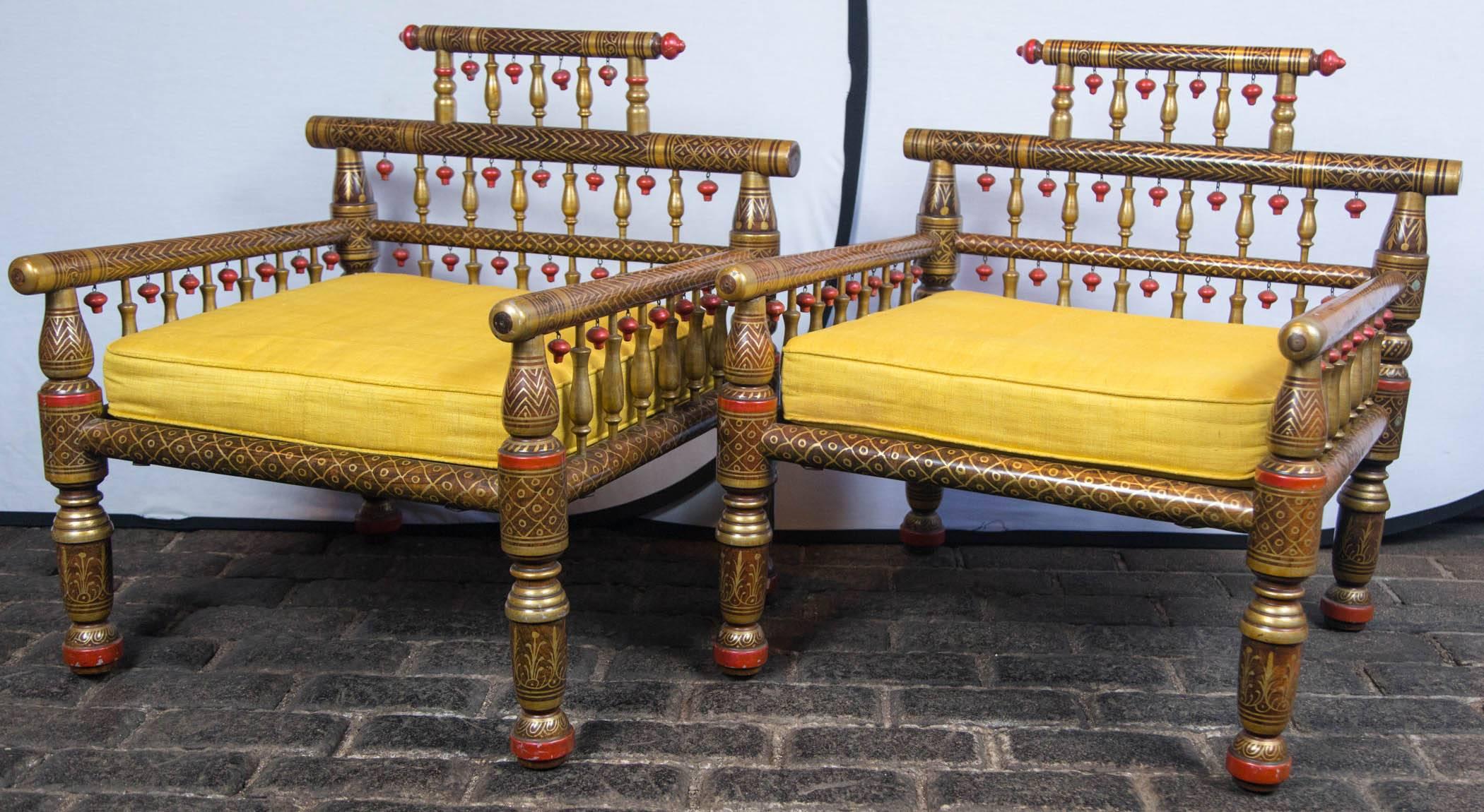 Pair of fanciful Anglo-Indian style armchairs with an intricate painted finish and carved wood 