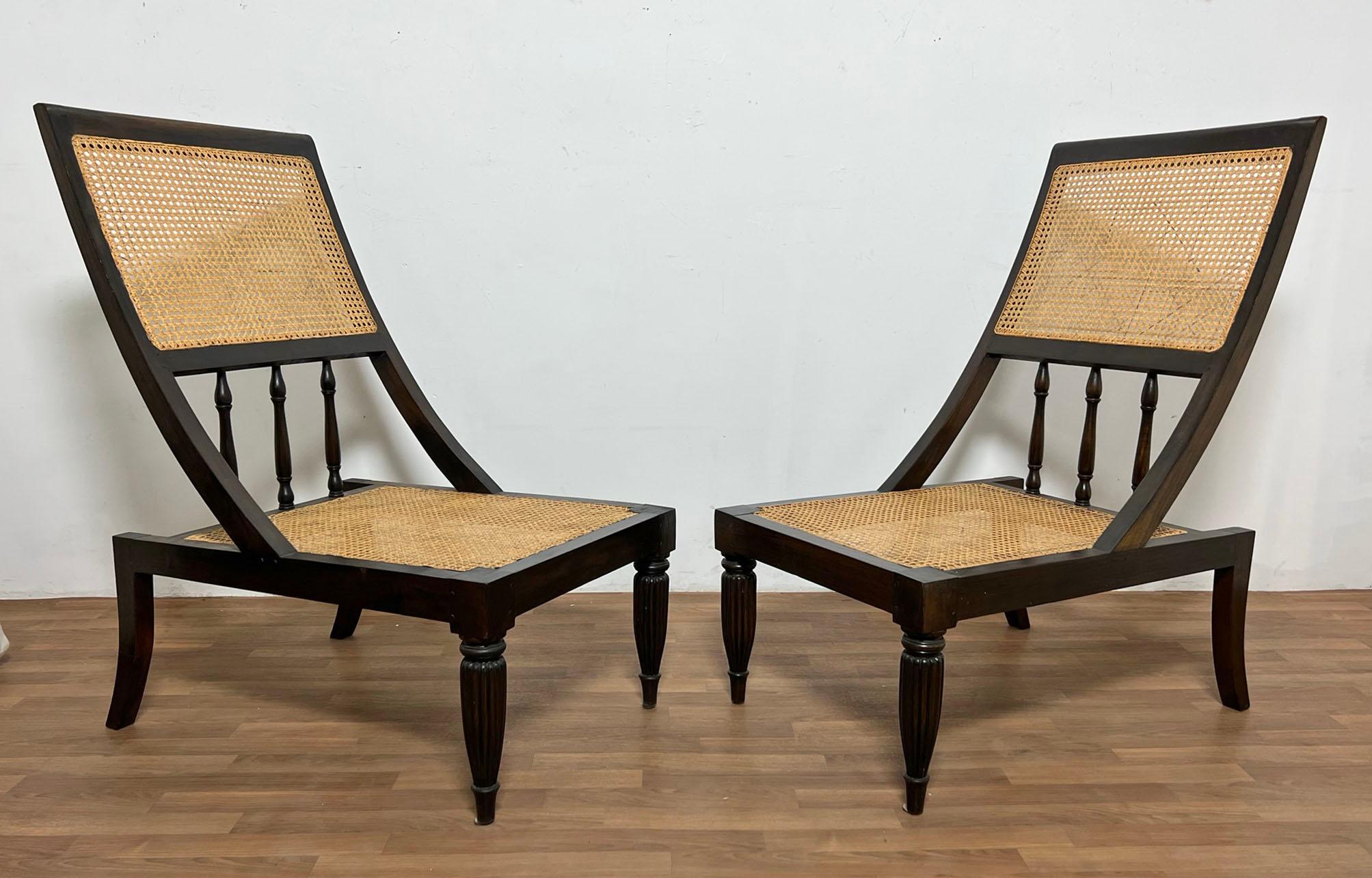 An unusual pair of Anglo-Indian style lounge chairs with gracefully canted backrests and front reeded Klismos legs, with elegant Klismos legs at the rear. We’re partial to an airier look and recommend these displayed with their cane panels