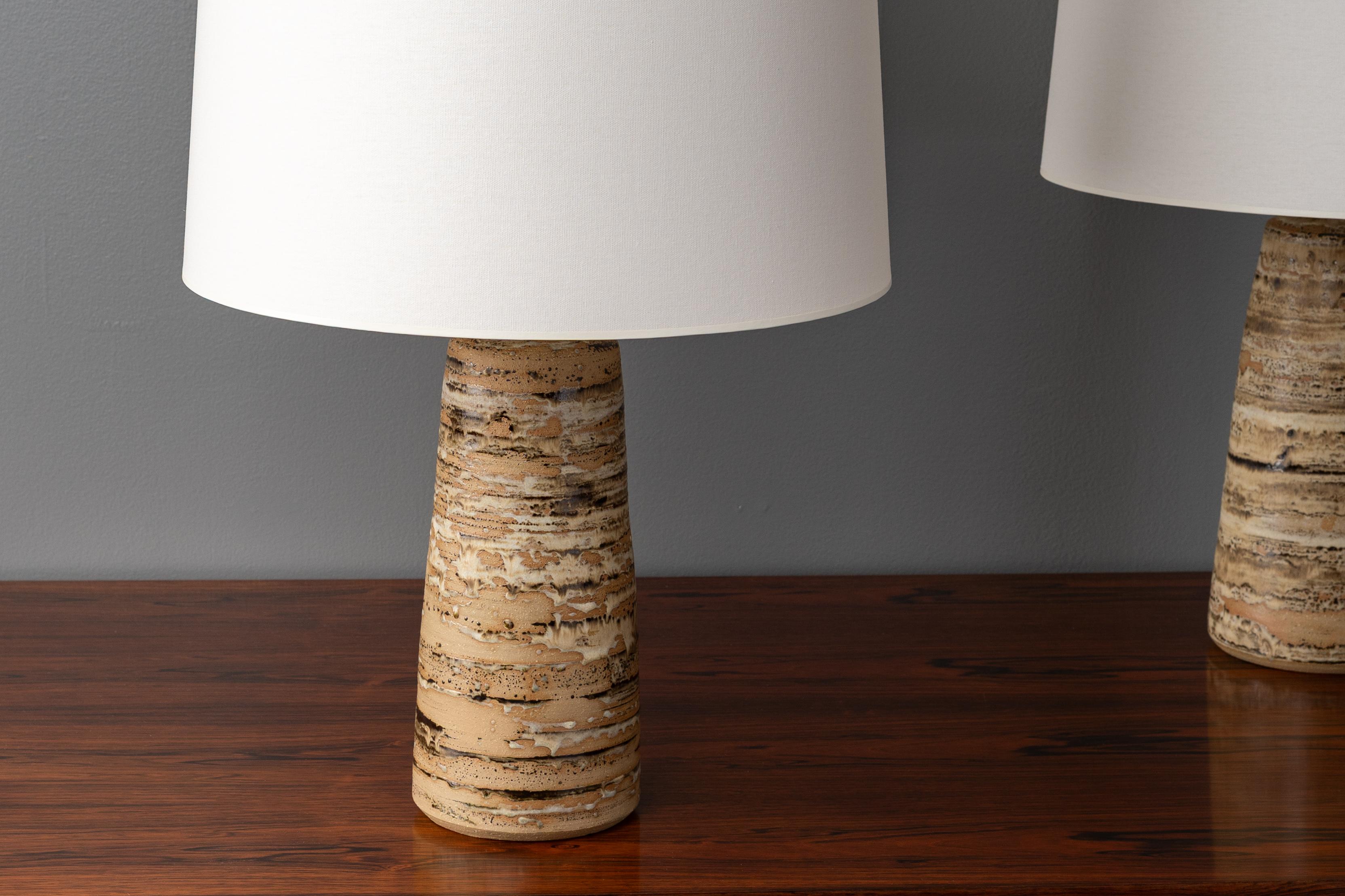 USA, ca. 1950s. A pair of studio table lamps by local ceramicist Anne Appleton Clarke (1925-1985). Each features sturdy, hand-thrown tapered construction with organic striated glaze. Professionally rewired and fitted with new linen shades that cast