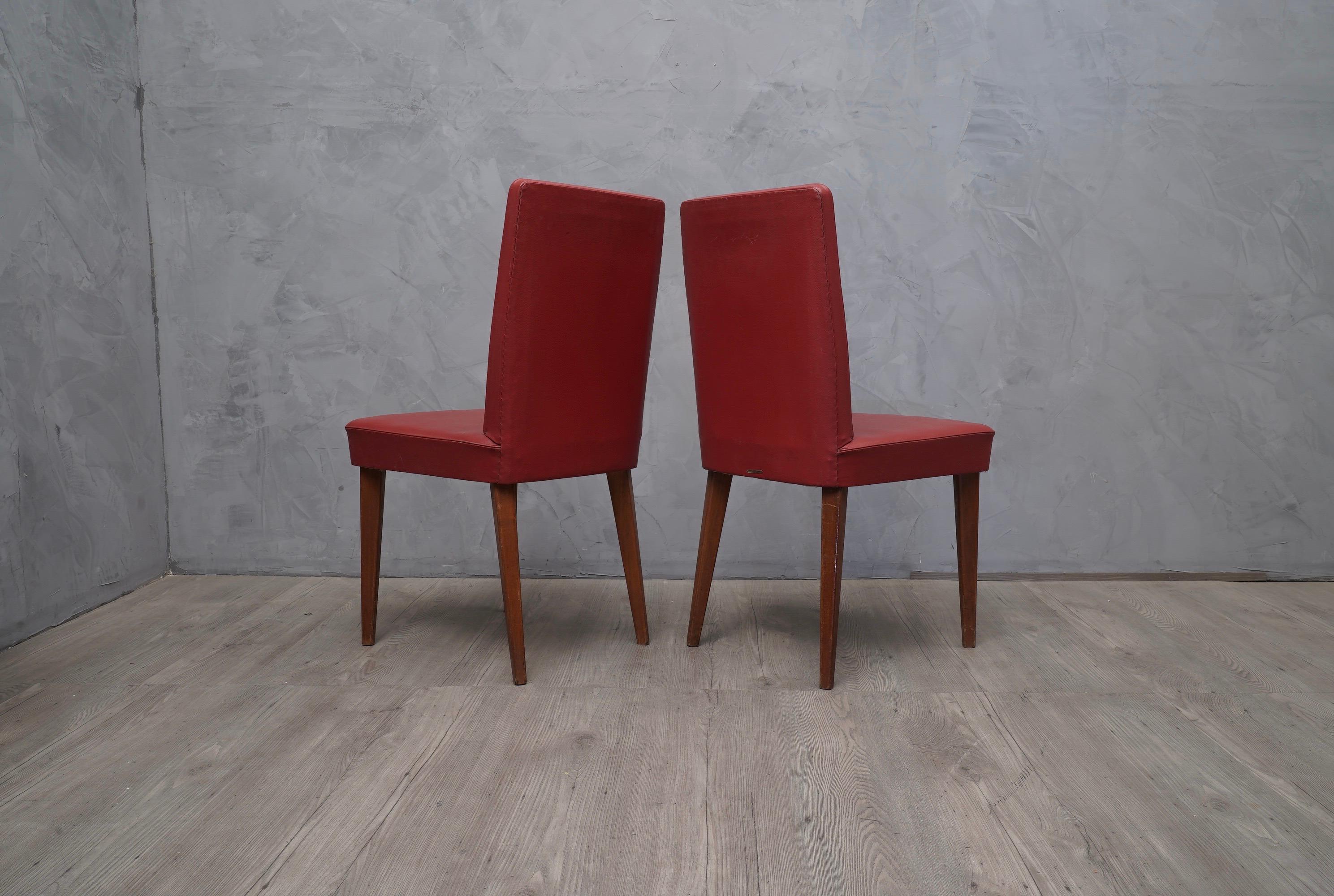 Pair of refined chairs of Anonima Castelli, with a beautiful bright red color.

Wooden structure, covered in red eco leather, original of the period. Four legs in oakwood lacquered. As you can see from the photos, it has a hallmark of the