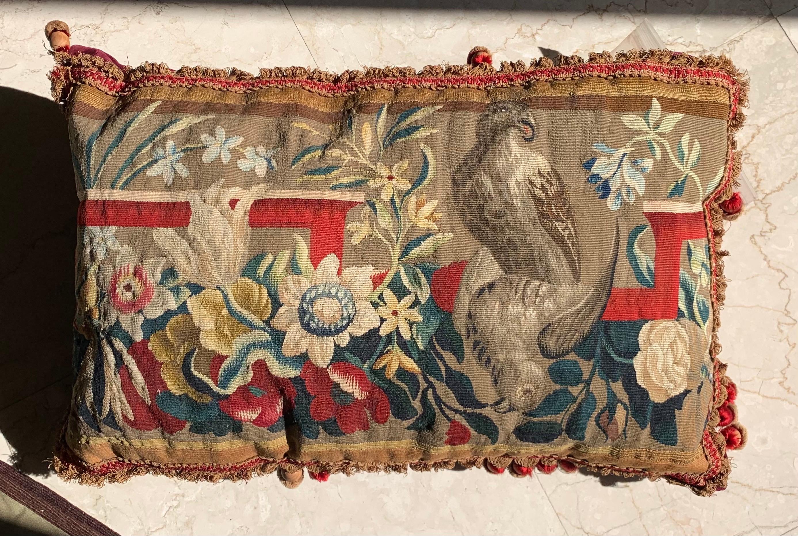 An exquisite pair of vibrant and stunning 17th Century Brussels Tapestry pillows with foliage and bird decor and petite tassels that will brighten up any sofa, canapé or settee! They are in excellent condition with velvet crimson backing and red