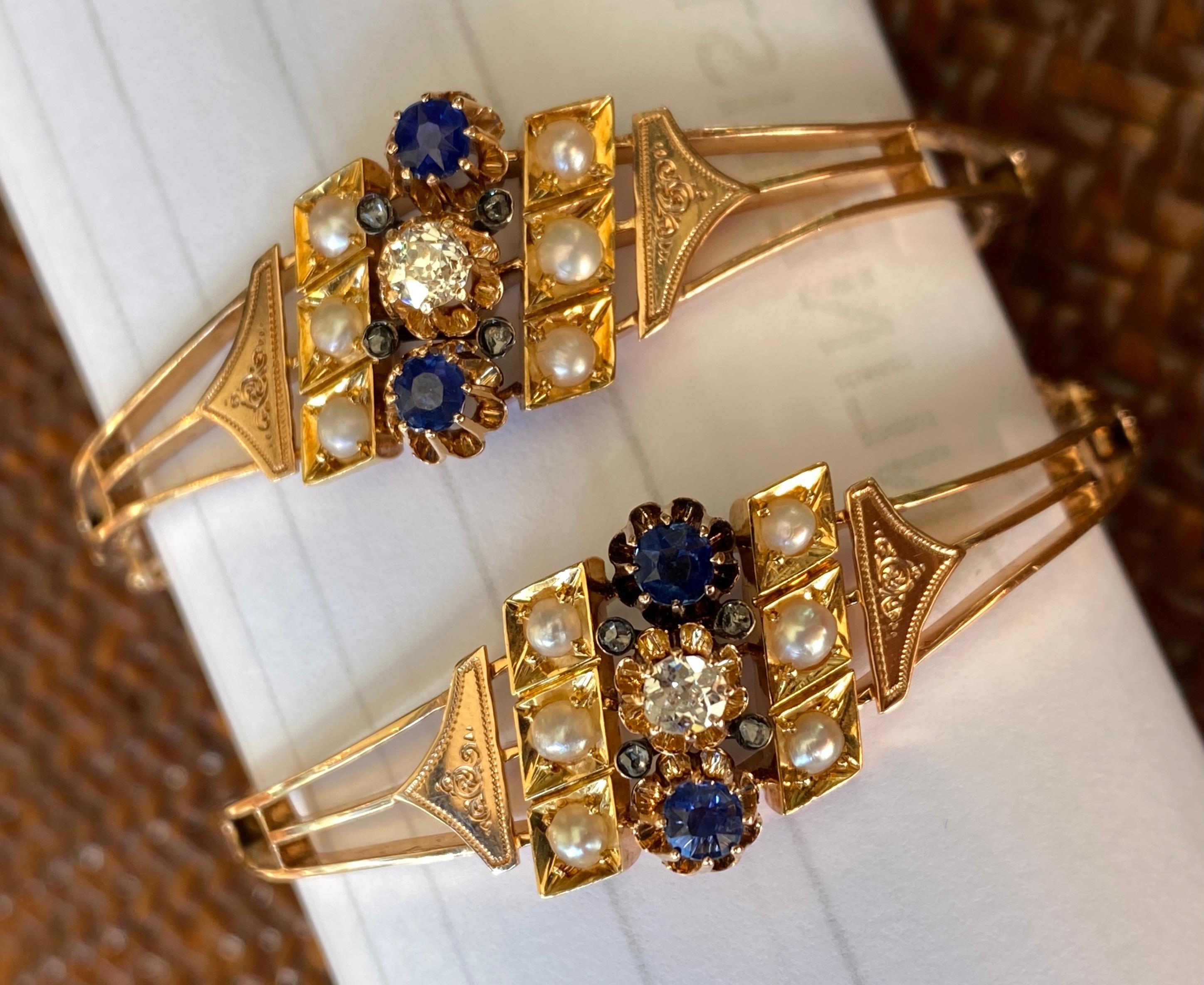 This exceptional pair of 14k gold Victorian wedding bangles date to 1891, late nineteenth century and are a superbly-matched set.  Each one has a center design with a sparkling old european cut diamond flanked by two sapphires in fine buttercup