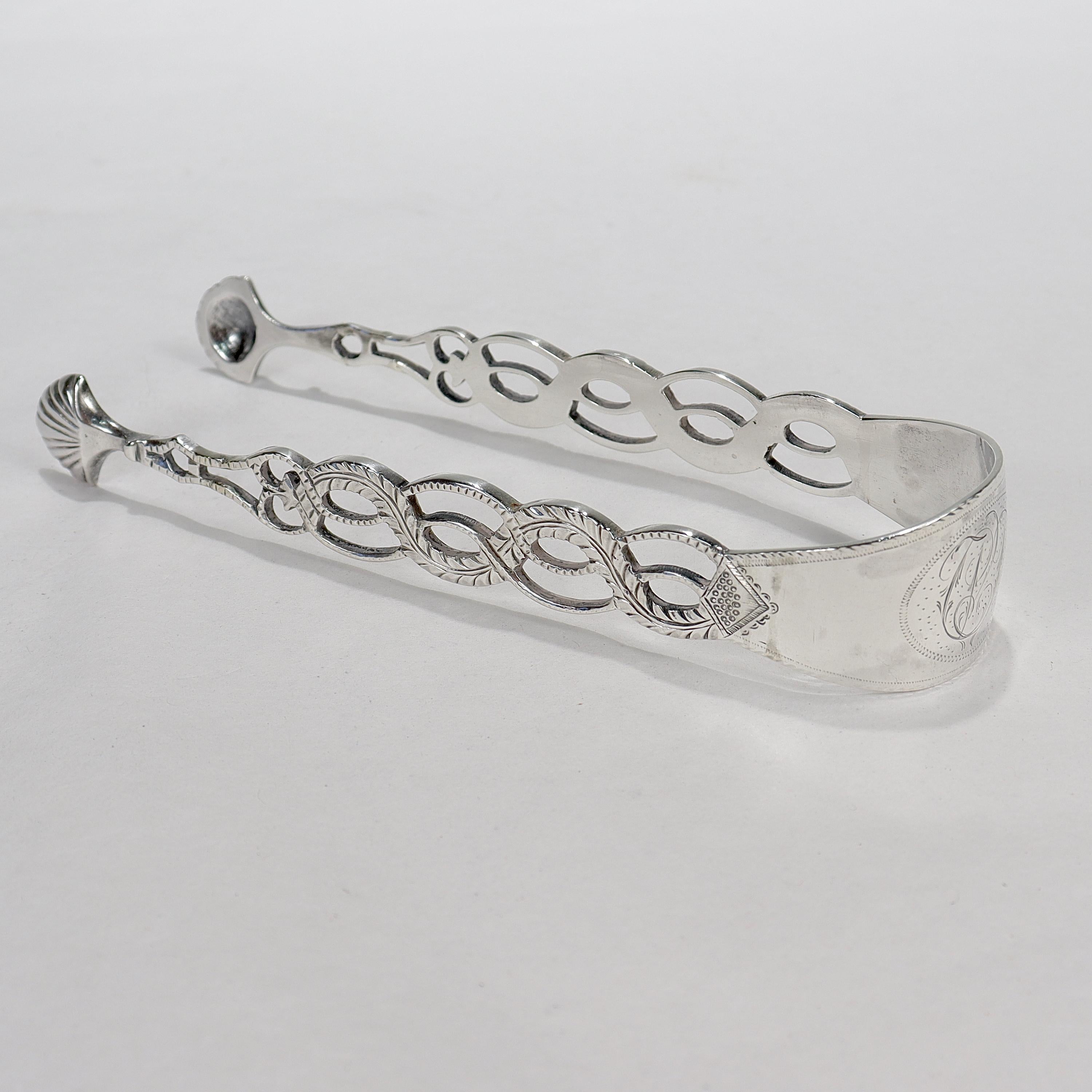 A fine pair of 18th Century silver sugar tongs.

In coin silver.

The arms of the tongs stylized as coiling ropes and terminating in figural seashell bowls.

Monogrammed to the middle of the tongs 
