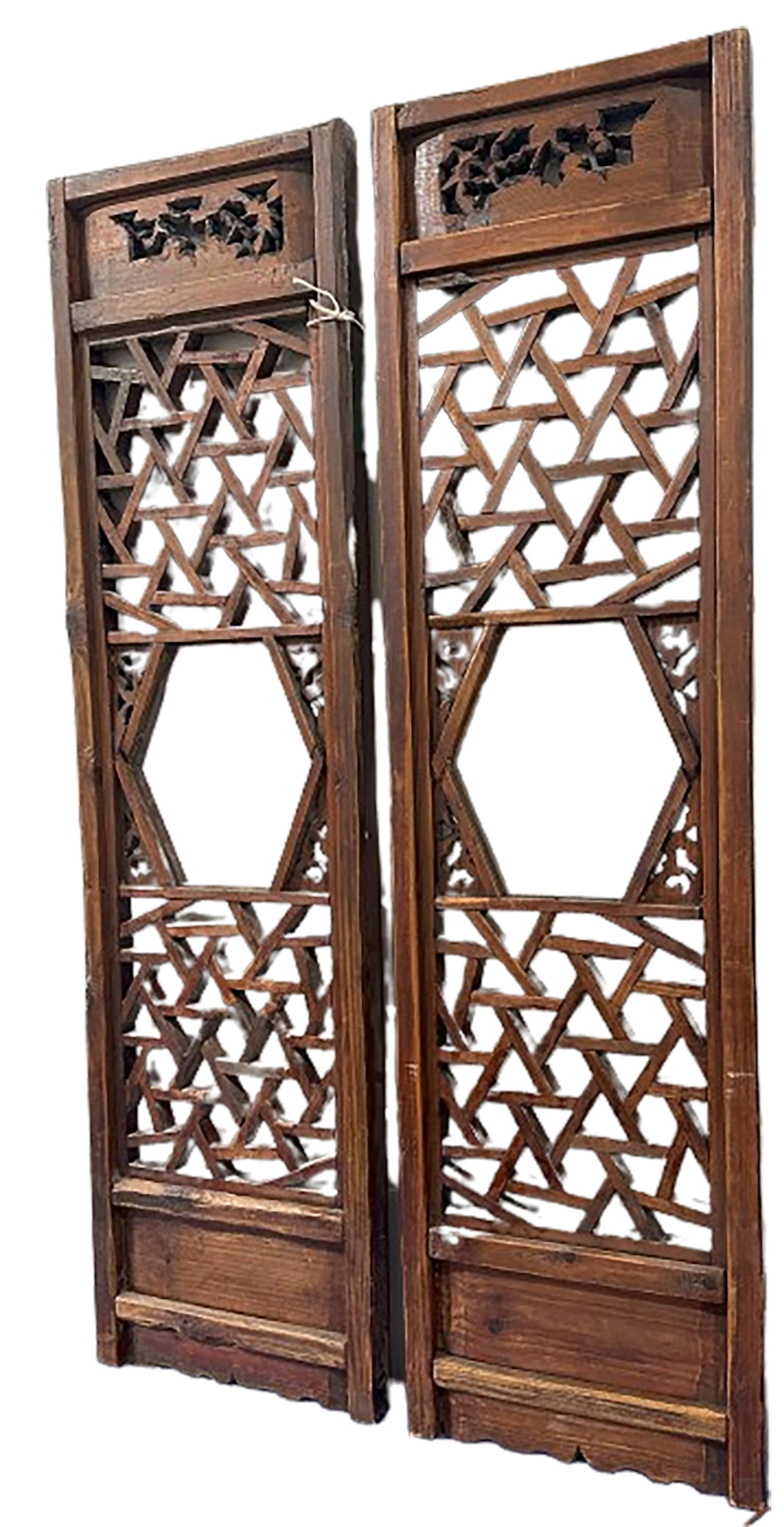 A handsome pair of fretted and carved wood Screen panels. Screens like these were often made as window decoration in Buddhist temples. They are traditionally handcrafted and structured with wooden pegs and tenon structure. Panels like these are also
