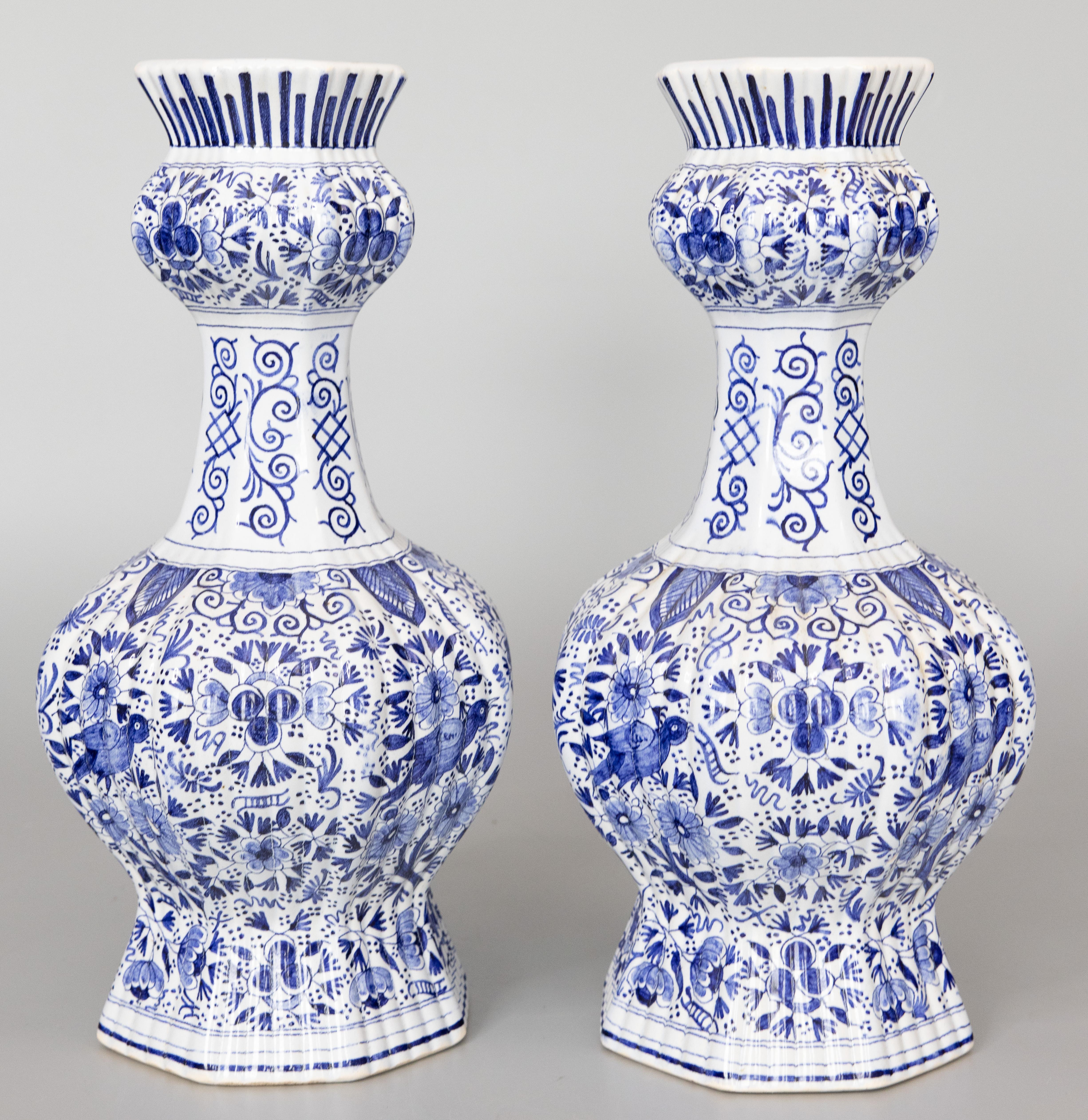 Superbe paire de vases à boutons en faïence de Delft, datant du 19e siècle, vers 1800. Marque du fabricant au revers. Ces superbes vases ont un corps nervuré avec des oiseaux, des fleurs, des feuilles et des volutes ornées peints à la main dans des