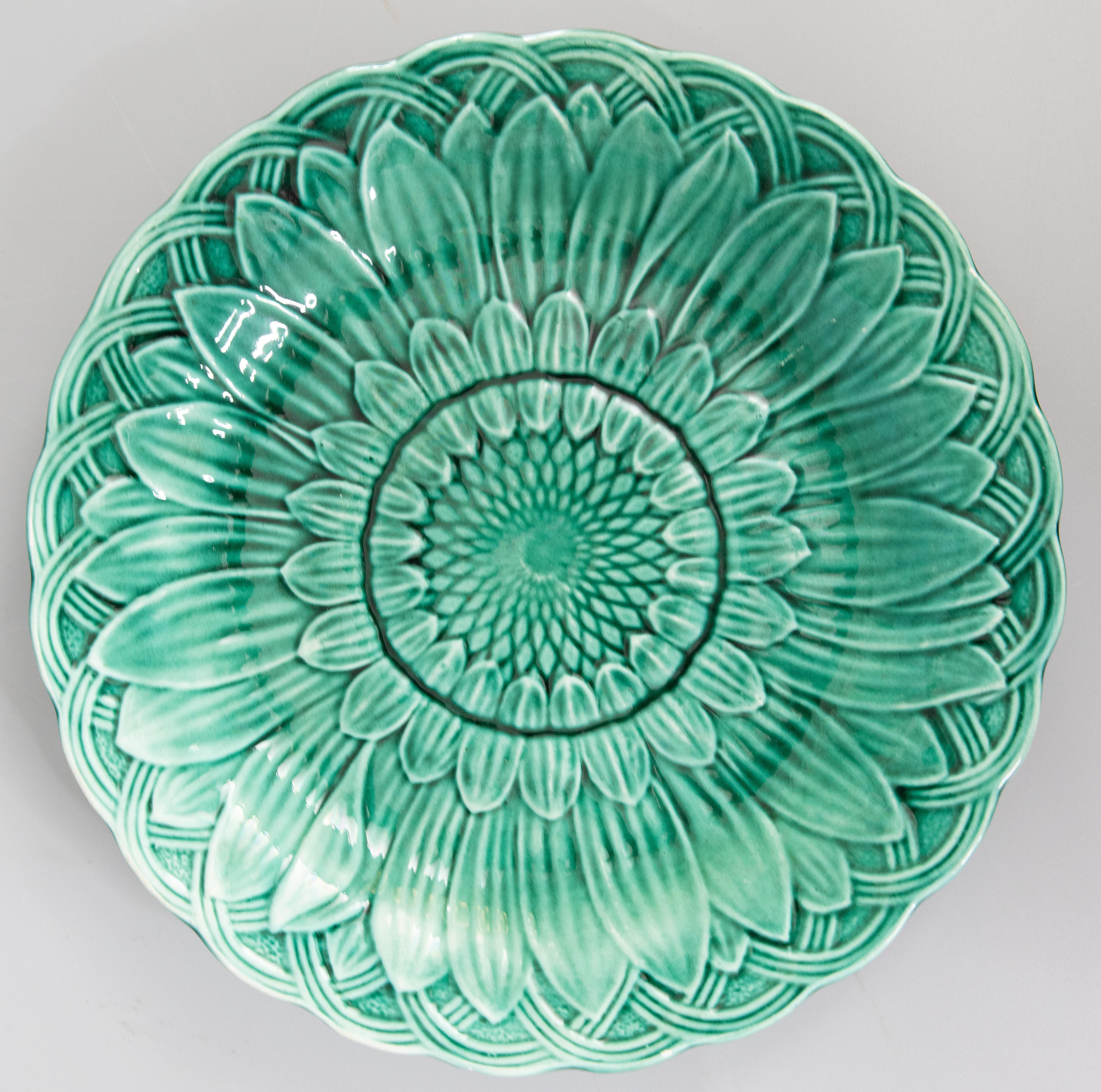 A lovely pair of antique English green glazed majolica leaf plates with a beautiful sunflower and basket weave design, circa 1870. These display beautifully and would be wonderful hung on a wall or placed in a cabinet, added to a collection, or used