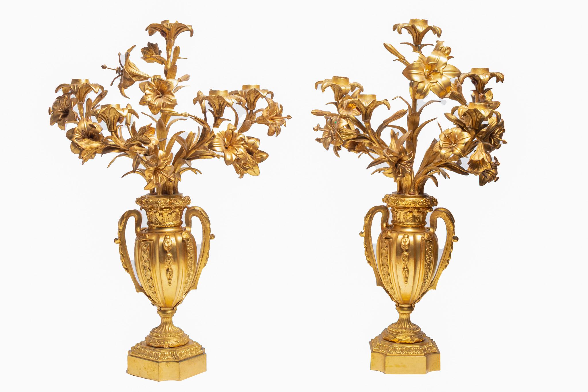 Exceptionnelle paire de candélabres à bouquet à cinq lumières en bronze doré du XIXe siècle. Chacune est modelée comme une fleur de lys avec de belles feuilles de fleurs autour des branches. Les lillies proviennent de deux urnes à poignée, chacune