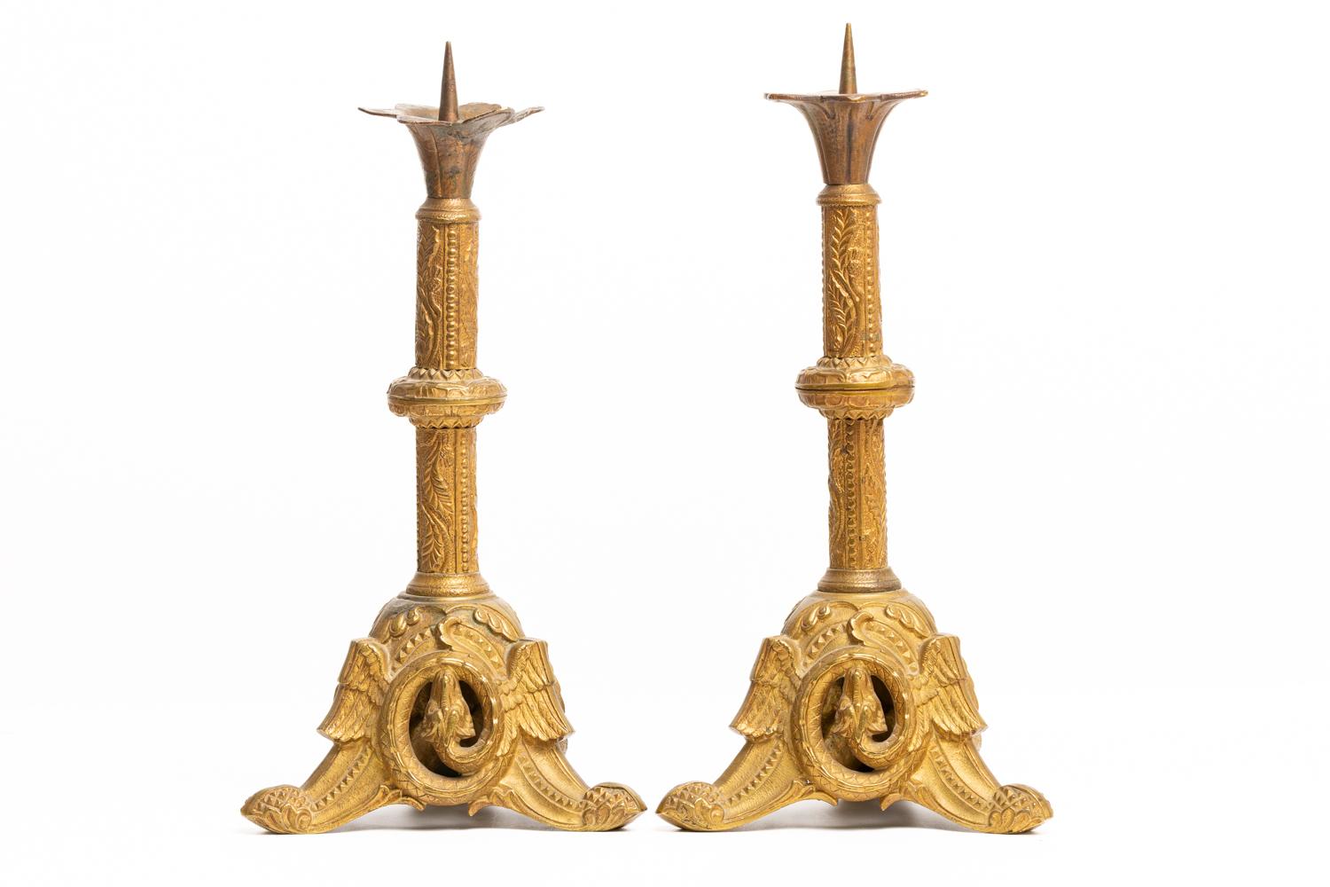 Rare and very ornate pair of French 19th century gilt brass altar candlesticks. The candlesticks are beautifully decorated with foliage and geometric design. Triangle base with winged dragons on each side of candlestick. Prickets would be perfect