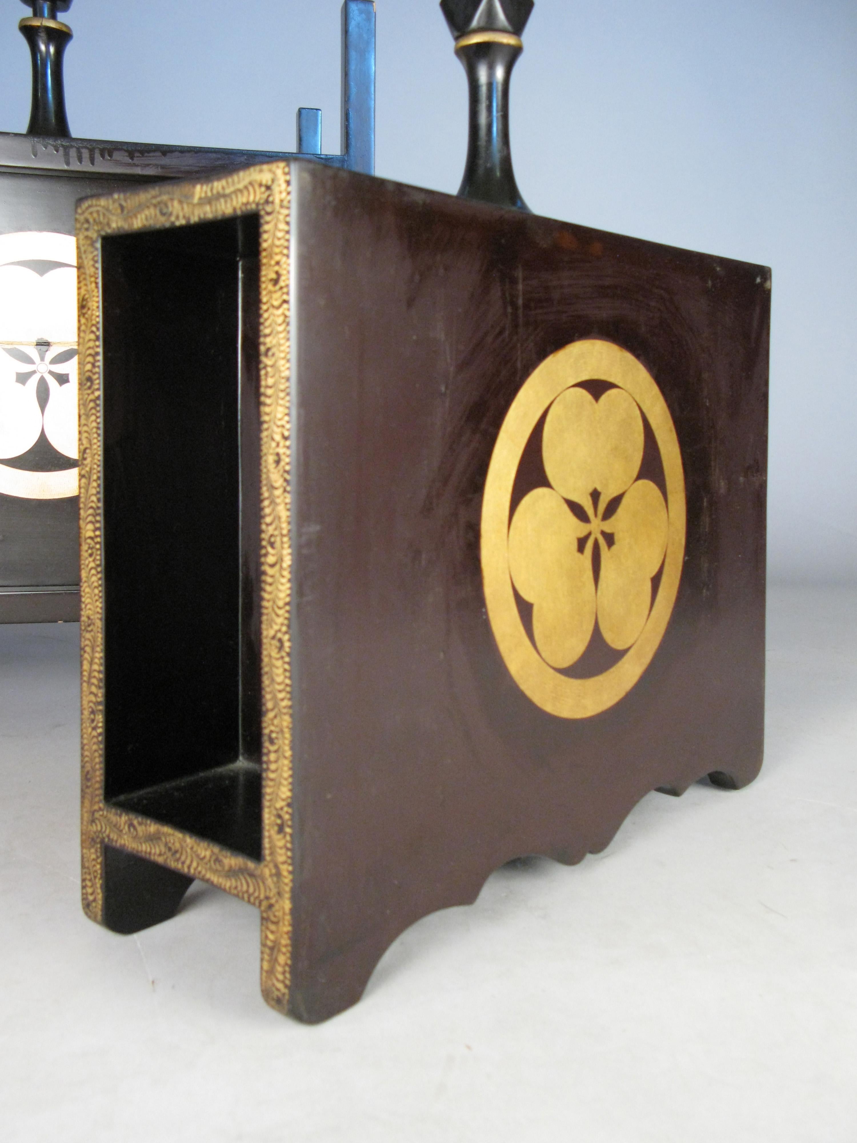 A beautiful pair of antique lacquered 19th century sake casks, in their wood open case. Each with a scalloped edge base, and gold leaf detailing. Each with a narrow cylindrical spout and a stopper with a rhomboid finial. The sides of each cask are