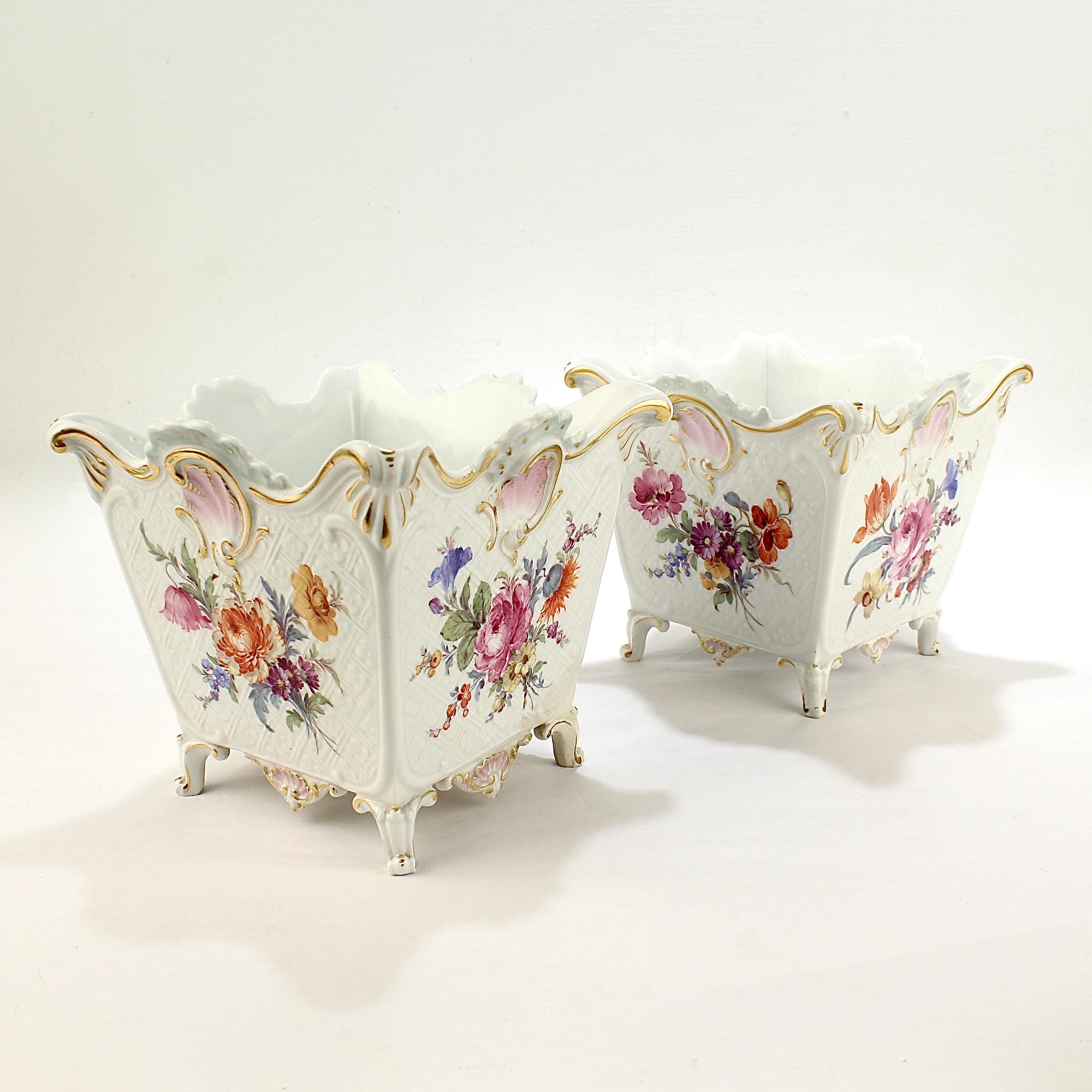 A pair of fine antique porcelain cachepots. 

By the Meissen Porcelain Manufactory. 

The body relief is molded in a basketwork and forget-me-not pattern and decorated with Deutsche Blumen floral bouquets and turquoise, pink, and blue