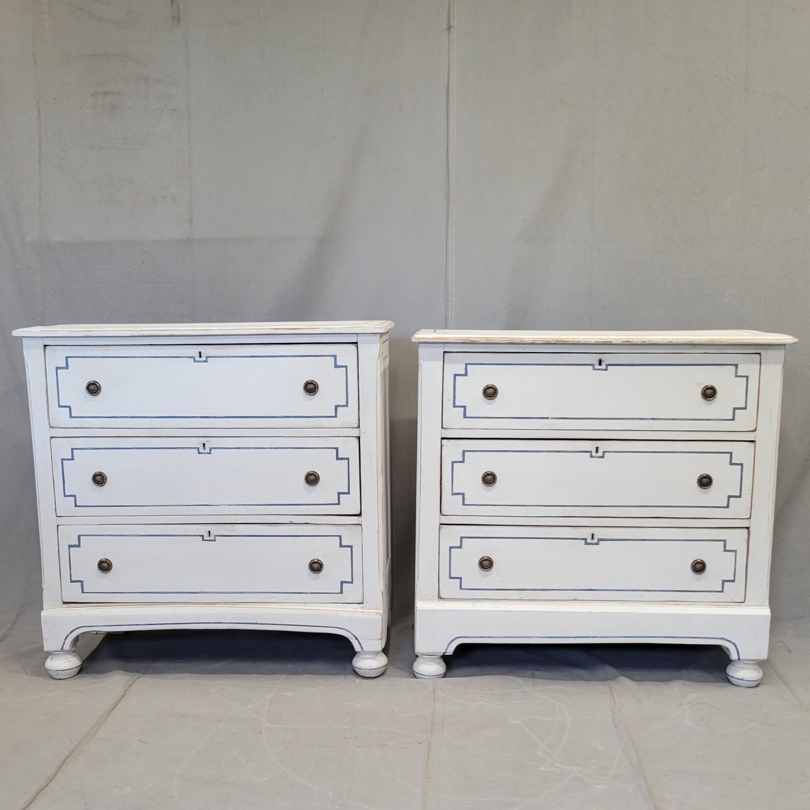 An absolutely charming near pair of pine dressers Recently painted in an antique manner with lead free white paint (often antique white paint has lead in it). The notched deep blue French line motif gives this pair such character. The distinctive