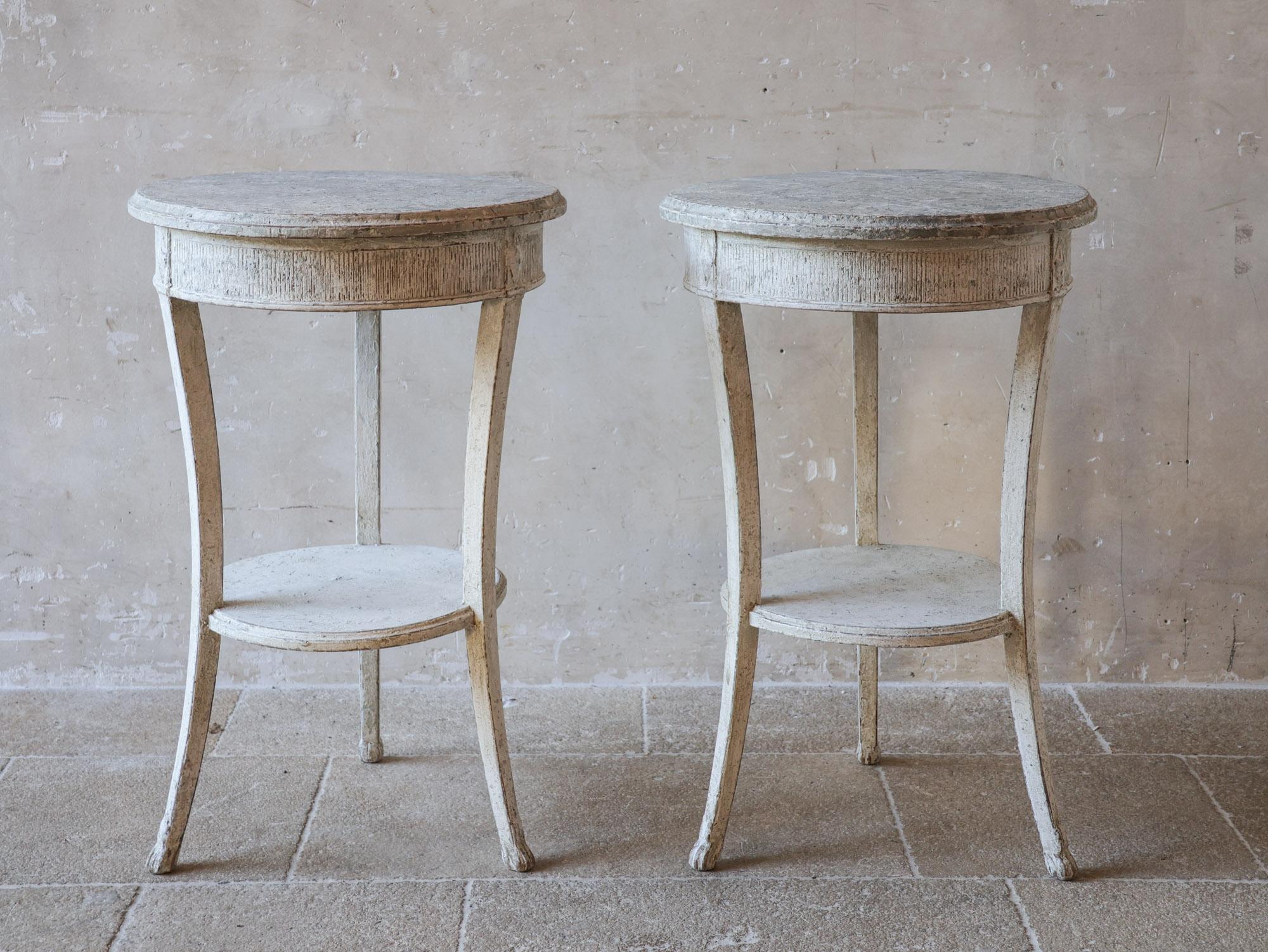 Ensemble de deux tables d'appoint françaises anciennes du 19e siècle. Les tables ont été restaurées ultérieurement avec une belle patine gris-blanc. Chaque table comporte trois pieds avec de petites griffes et un rebord sous le plateau de la table.