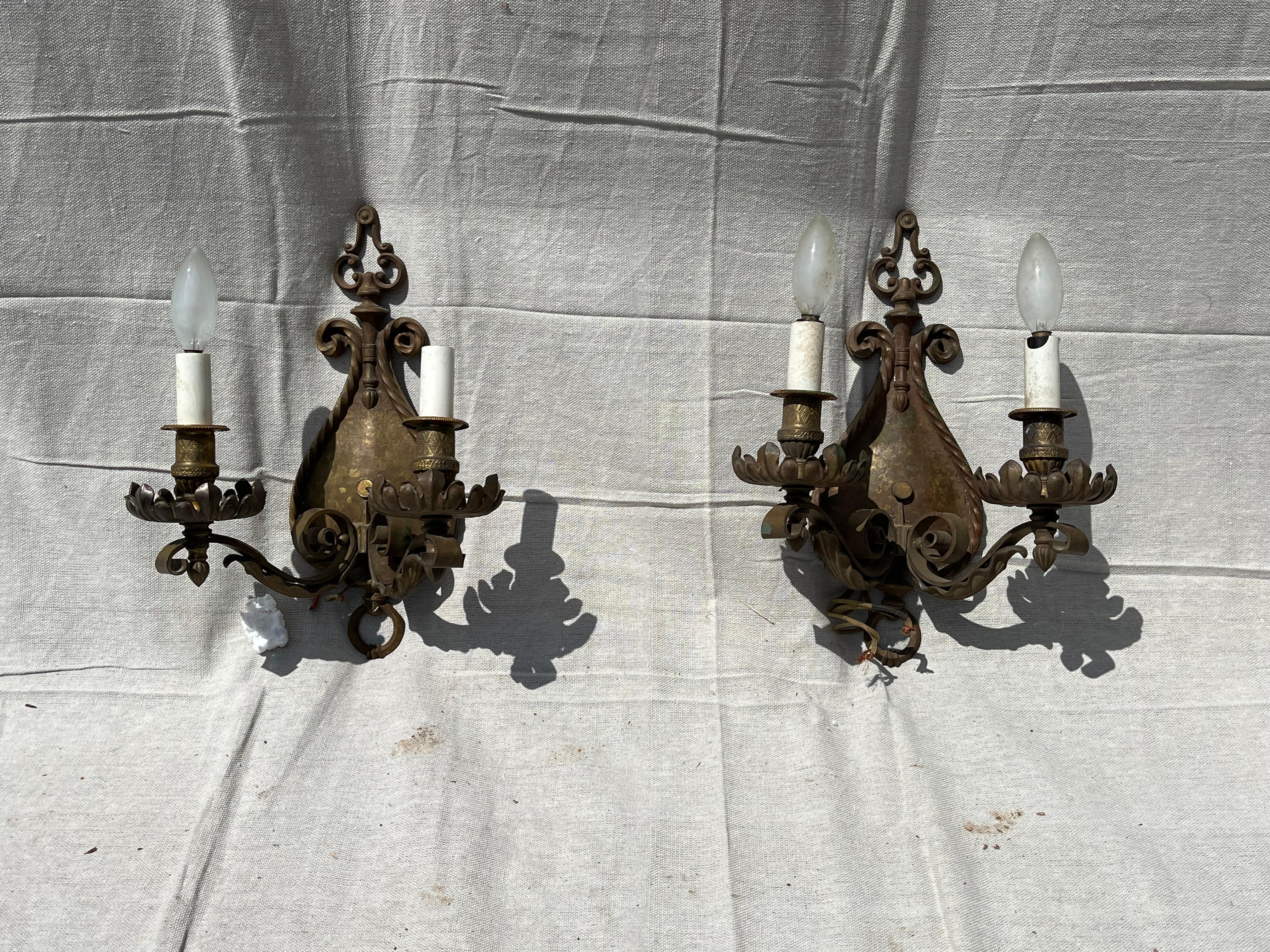A pair of bronze 2-arm wall sconces, with hand-hammered back plate trimmed with a twisted rope detail and French style bobeches.