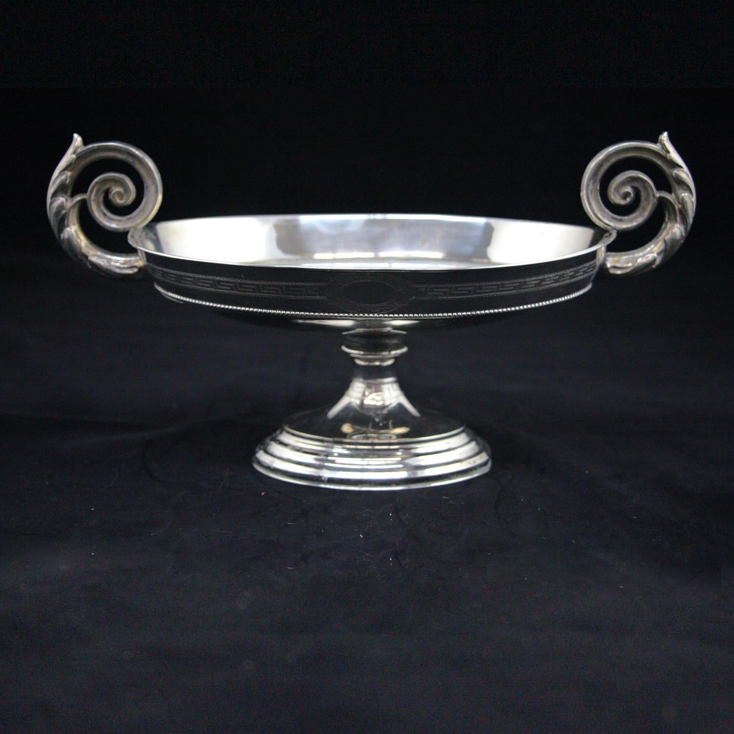 A pair of antique Adam style neoclassical .800 silver compotes feature oval form bowl with Greek Key patterning and each having double foliate scroll form handles, raised on pedestal with stepped base, 20.6 toz, circa 1820.

Measure: 7.5