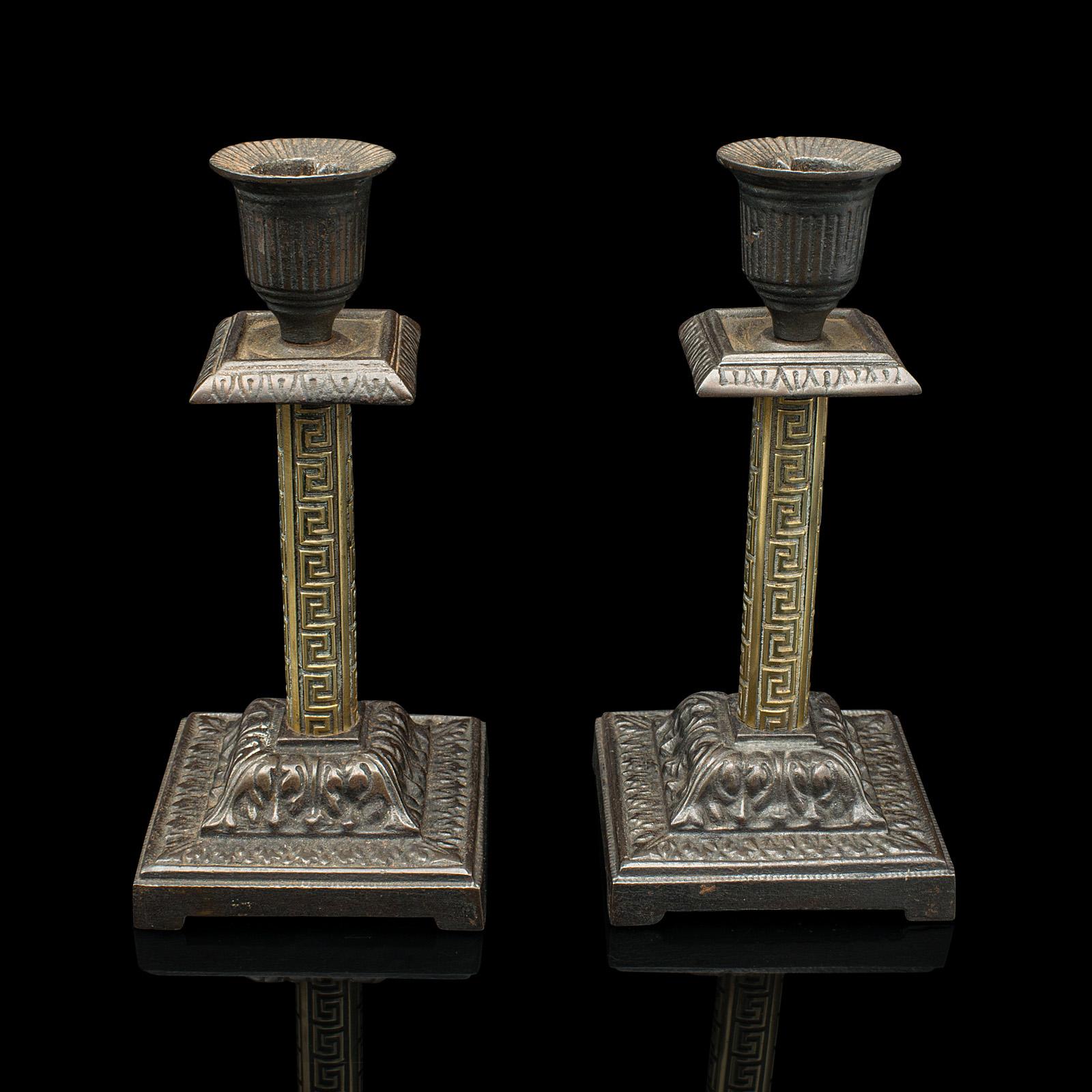 This is a small pair of Aesthetic Period candlesticks. An English, brass and cast iron candle stand, dating to the late Victorian period, circa 1890.

Petite and tastefully decorative pair, ideal for an intimate evening
Displaying a desirable aged