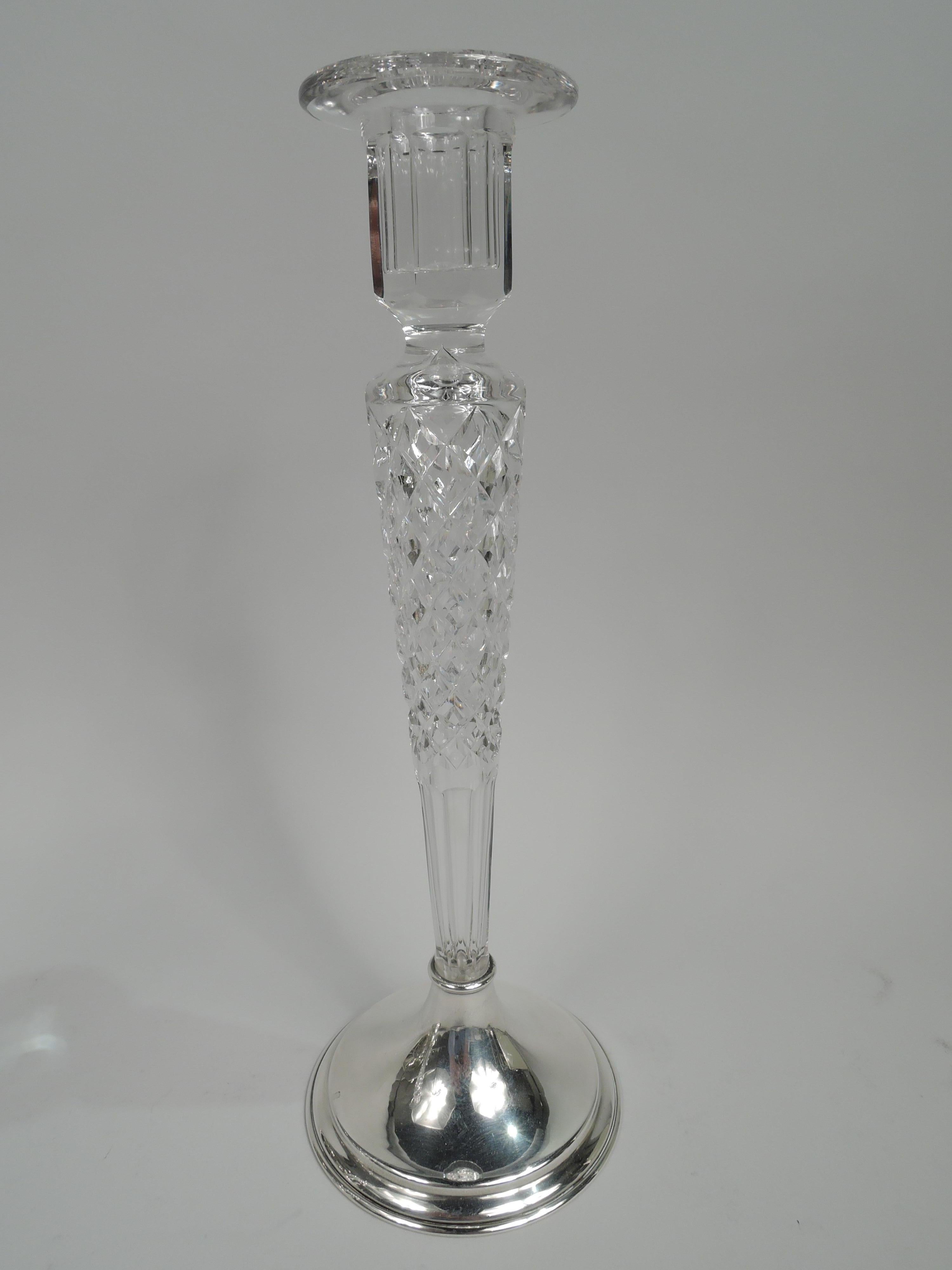 Pair of American Edwardian glass and sterling silver candlesticks, ca 1920. Each: Faceted glass socket with flat rim mounted to same tapering shaft with relief diaper and faceted base. Raised and sterling silver foot. Marked “S819 / Sterling / 58