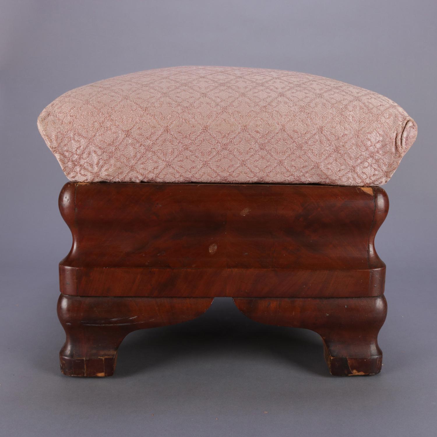 A pair of antique American Empire footstools feature flame mahogany ogee form bases with removable upholstered seats opening to reveal storage compartments, circa 1880

Measure: 14.5
