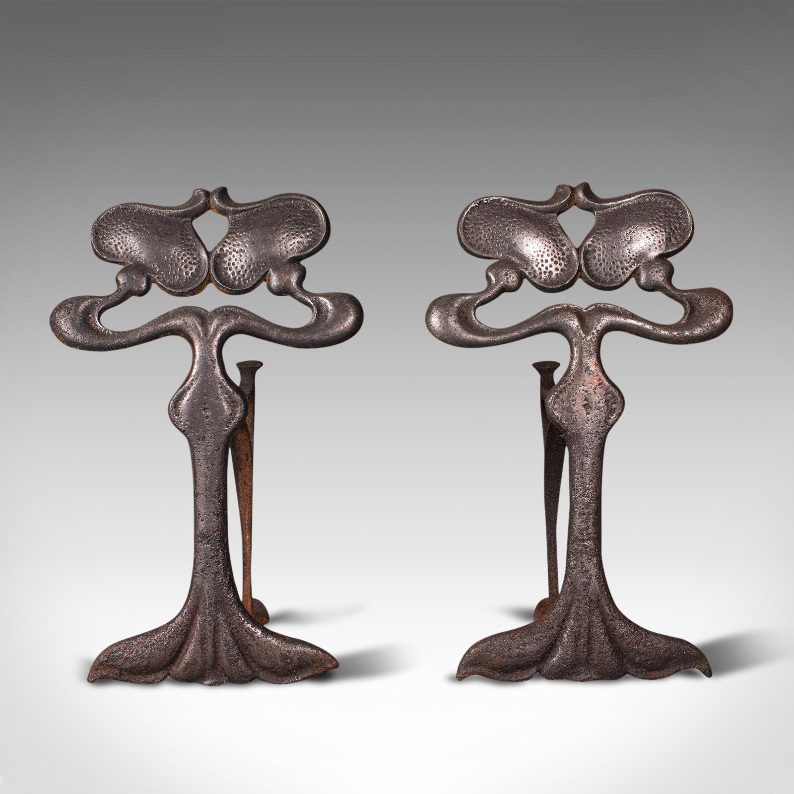 This is a pair of antique andirons. A French, cast iron fireside fire dog or tool rests in Art Nouveau taste, dating to the late 19th century, circa 1900.

Superb and expressive forms in the Art Nouveau manner
Displaying a desirably aged patina