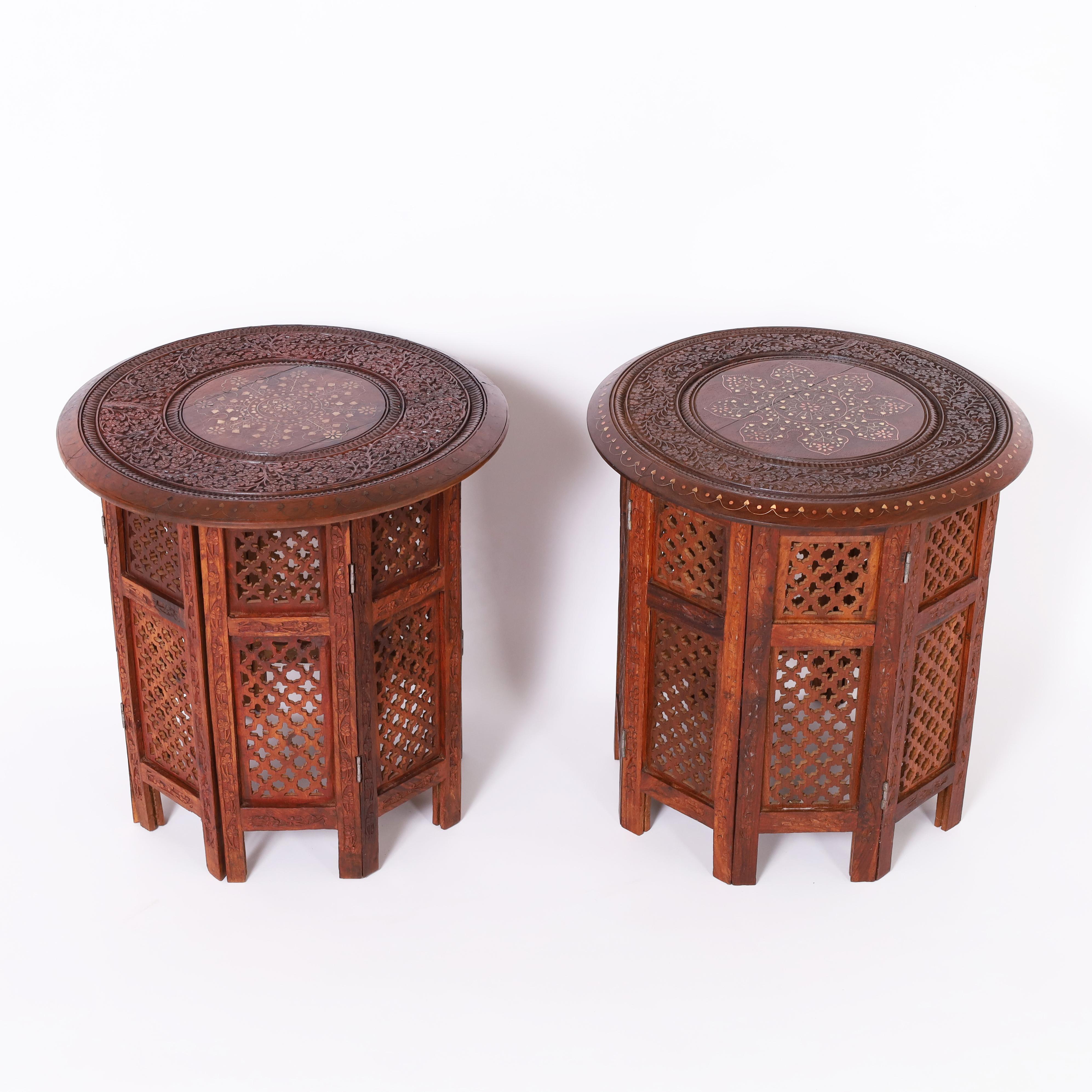 Ancienne paire de supports anglo-indiens fabriqués à la main en acajou avec des plateaux ronds et des médaillons centraux incrustés de cuivre et de laiton dans des motifs floraux, à l'intérieur de bordures florales sculptées. Les bases de forme