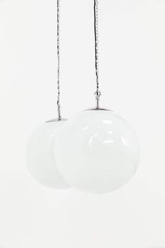 Par de lámparas colgantes antiguas de cristal opalino con forma de globo, estilo Art Déco, hacia 1930