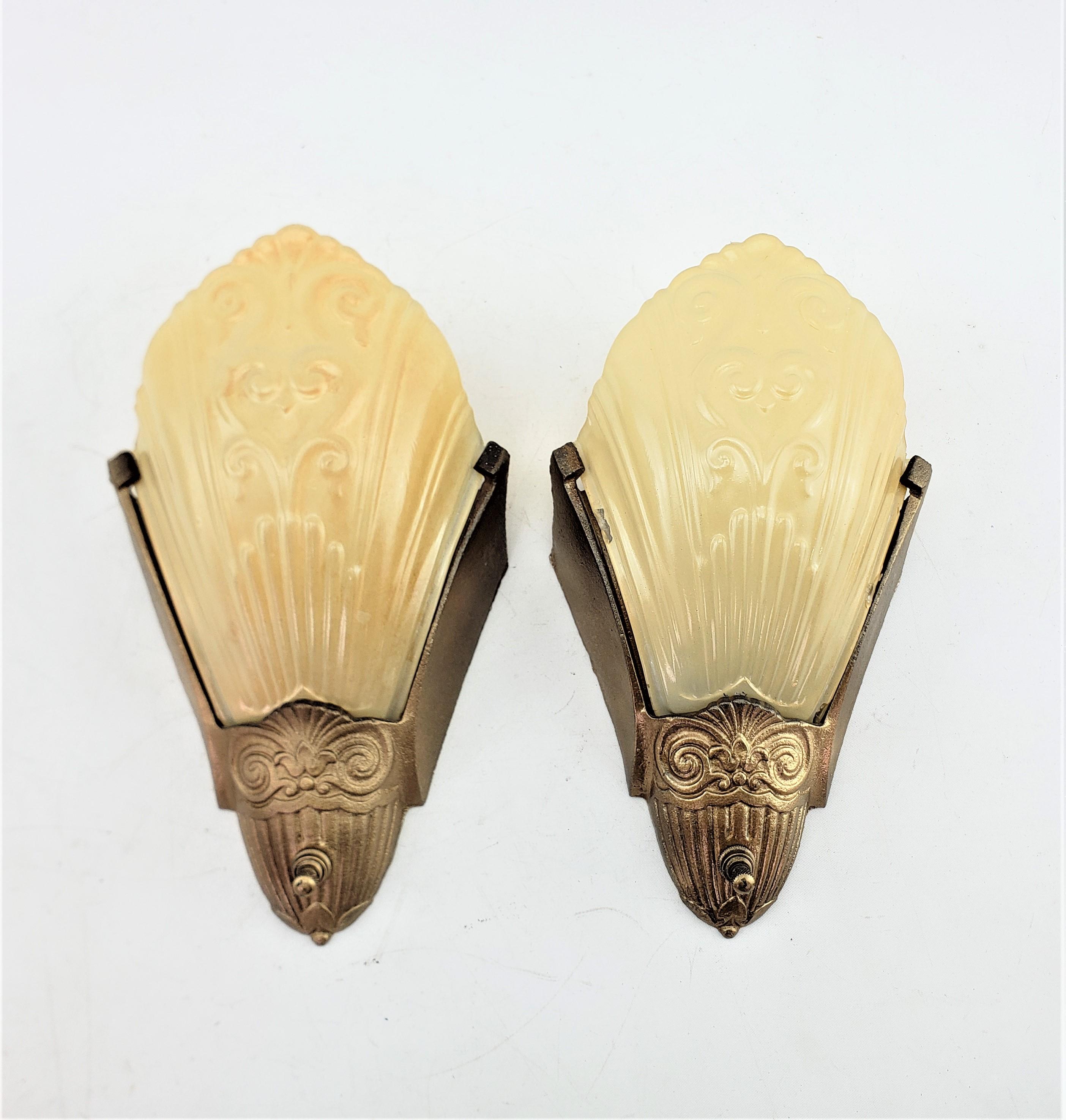 This pair of wall sconces were made by the well known J.C. Virden Co. of the United States and date to approximately 1920 and done in the period Art Deco style. The wall mounting brackets are done in a cast metal with a bronze patination, and the
