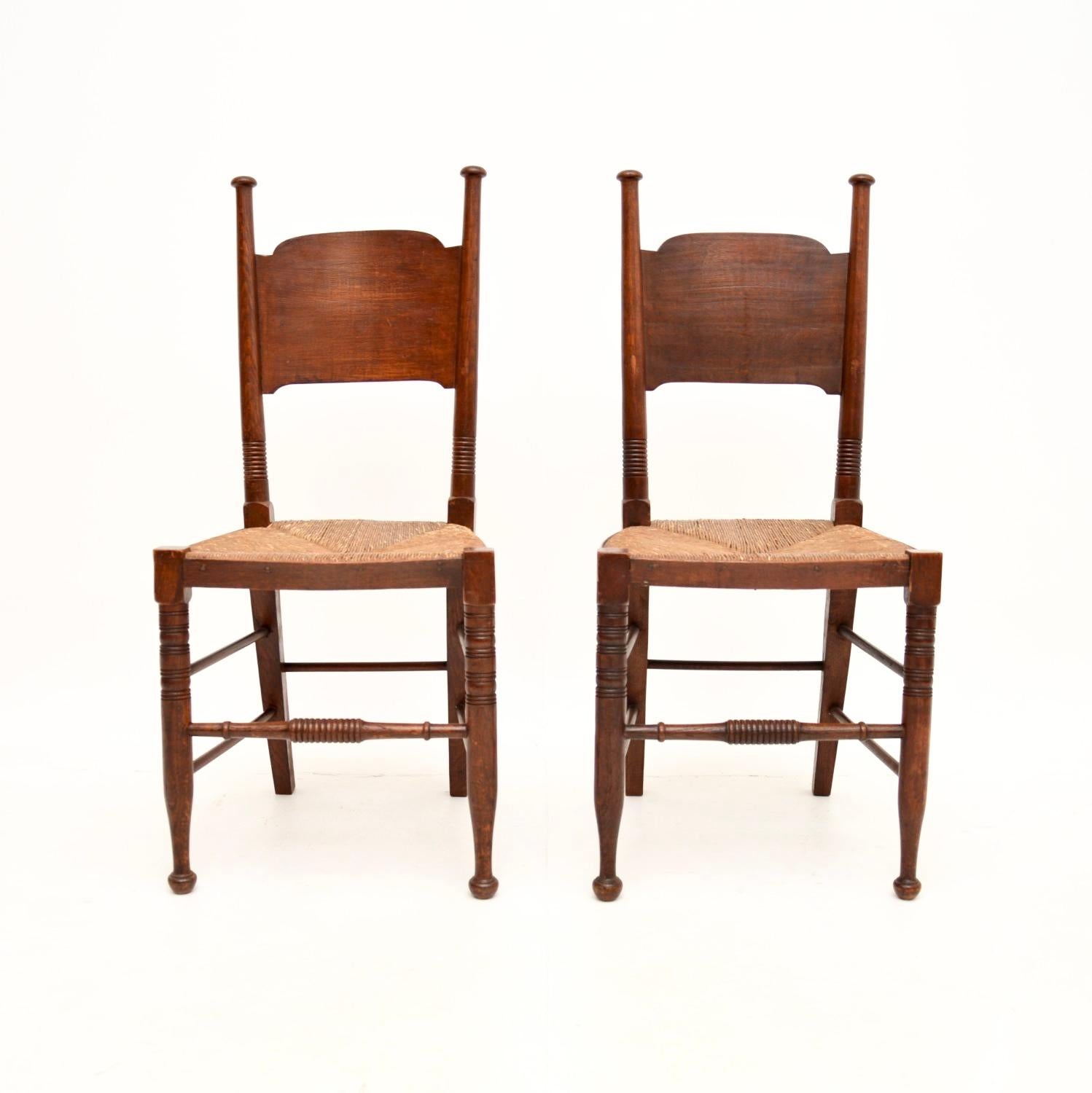 A stunning and iconic pair of antique Arts and Crafts side chairs by William Birch. They were made in England, they date from around the 1890-1900 period.

They are beautifully made and designed, the frames are oak with lovely rushed seats.

The