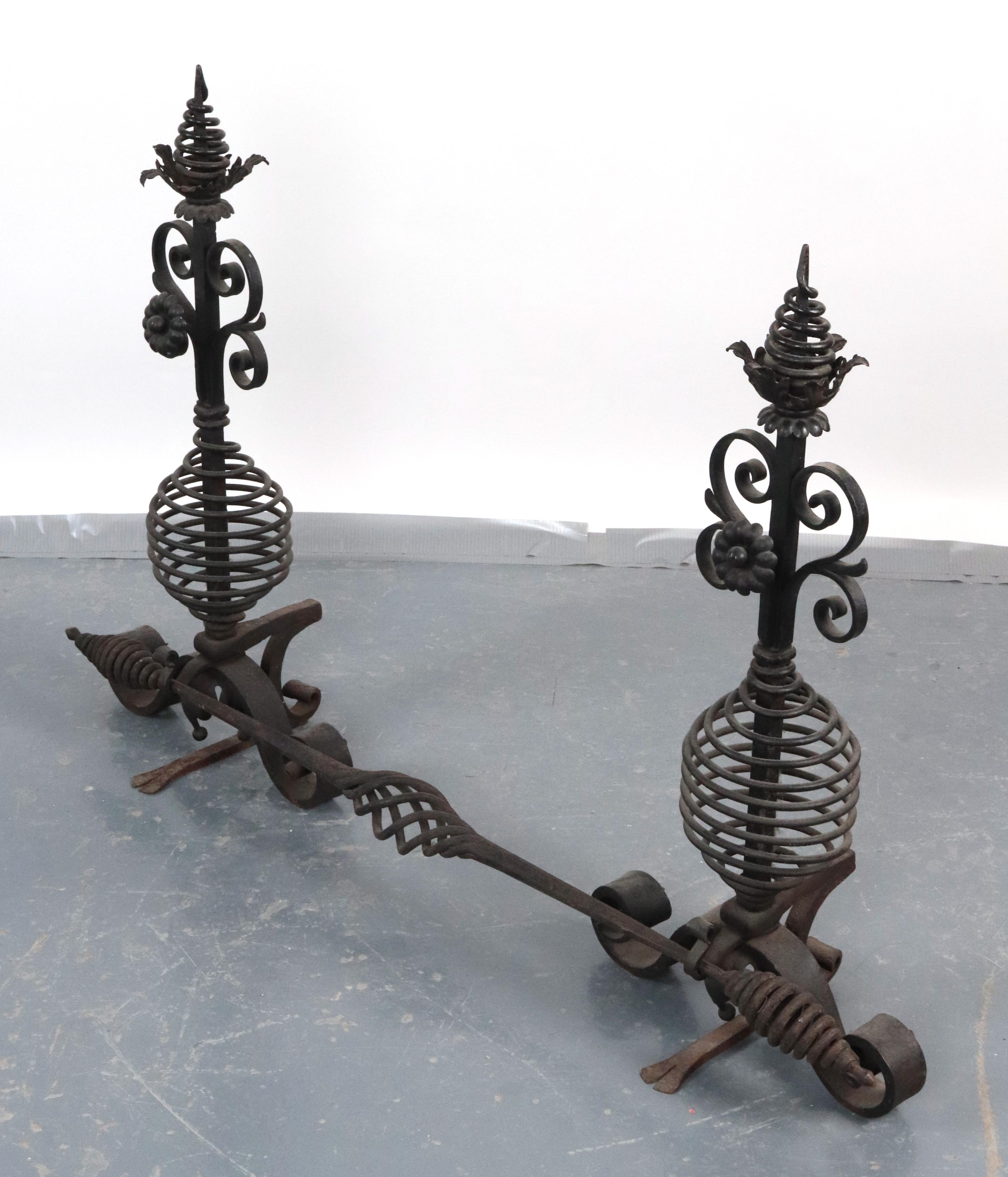 I candelabri in ferro battuto per caminetto in stile Arts & Crafts sono caratterizzati da terminali a spillo, accenti a voluta e a spirale, gambo a gabbia e piedi arricciati. C'è una barra con un motivo intrecciato che collega i due pezzi. I