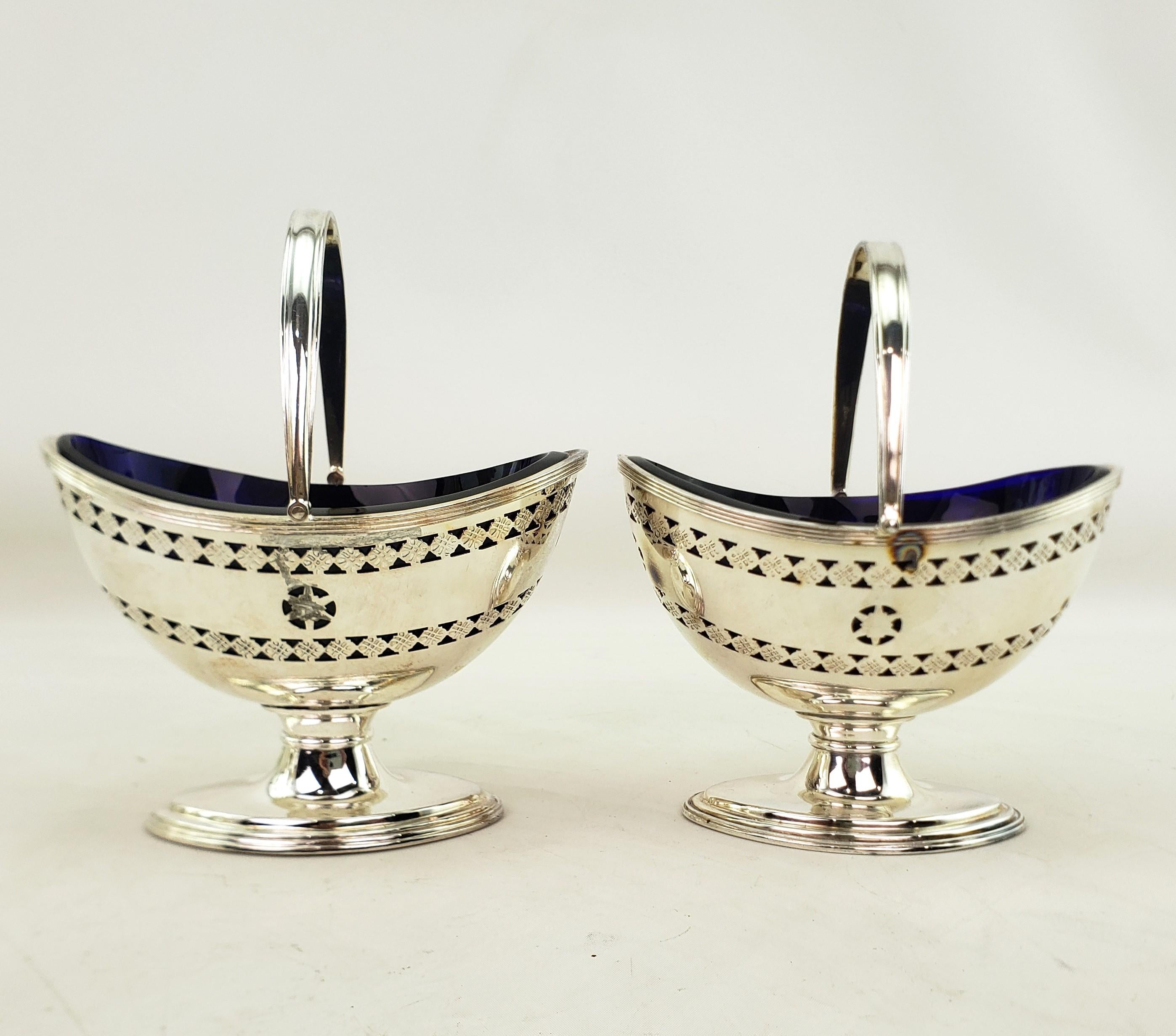 This pair of antique condiment servers were made by the well known Barker-Ellis Silver Company of England and date to approximately 1920 and done in a Victorian style. The servers are composed of silver plate and done in an oval basket form with