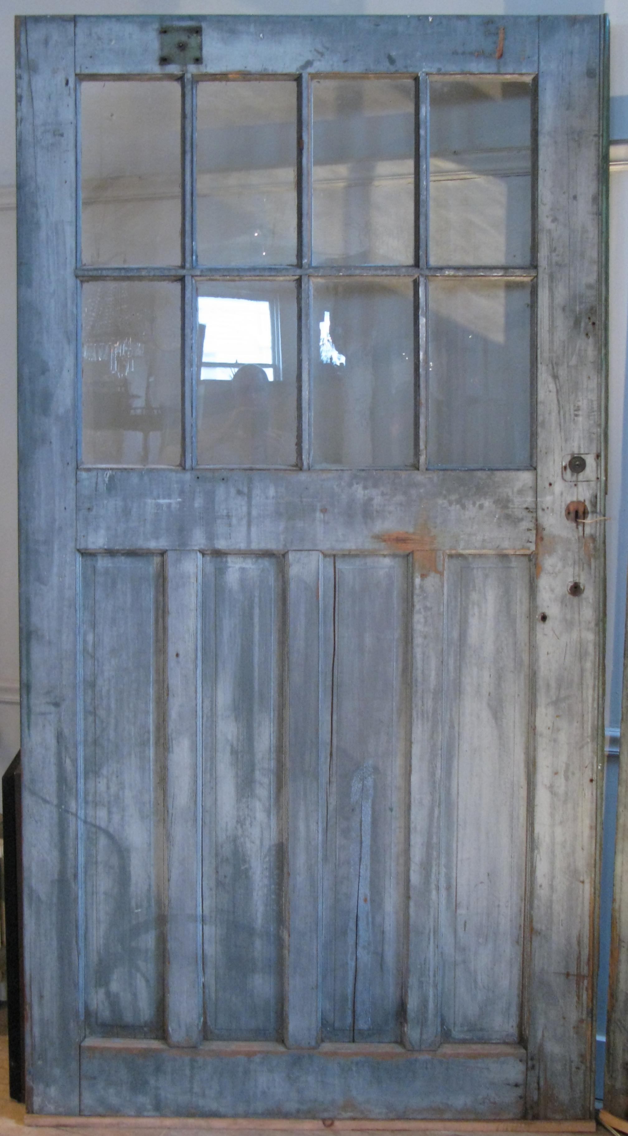 A large pair of beautiful early 20th century barn doors, each with 4 over 4 divided pane glass windows. One side is old blue/grey painted finish, and the other side is brick red. Very good condition and well made.

Each door is 48