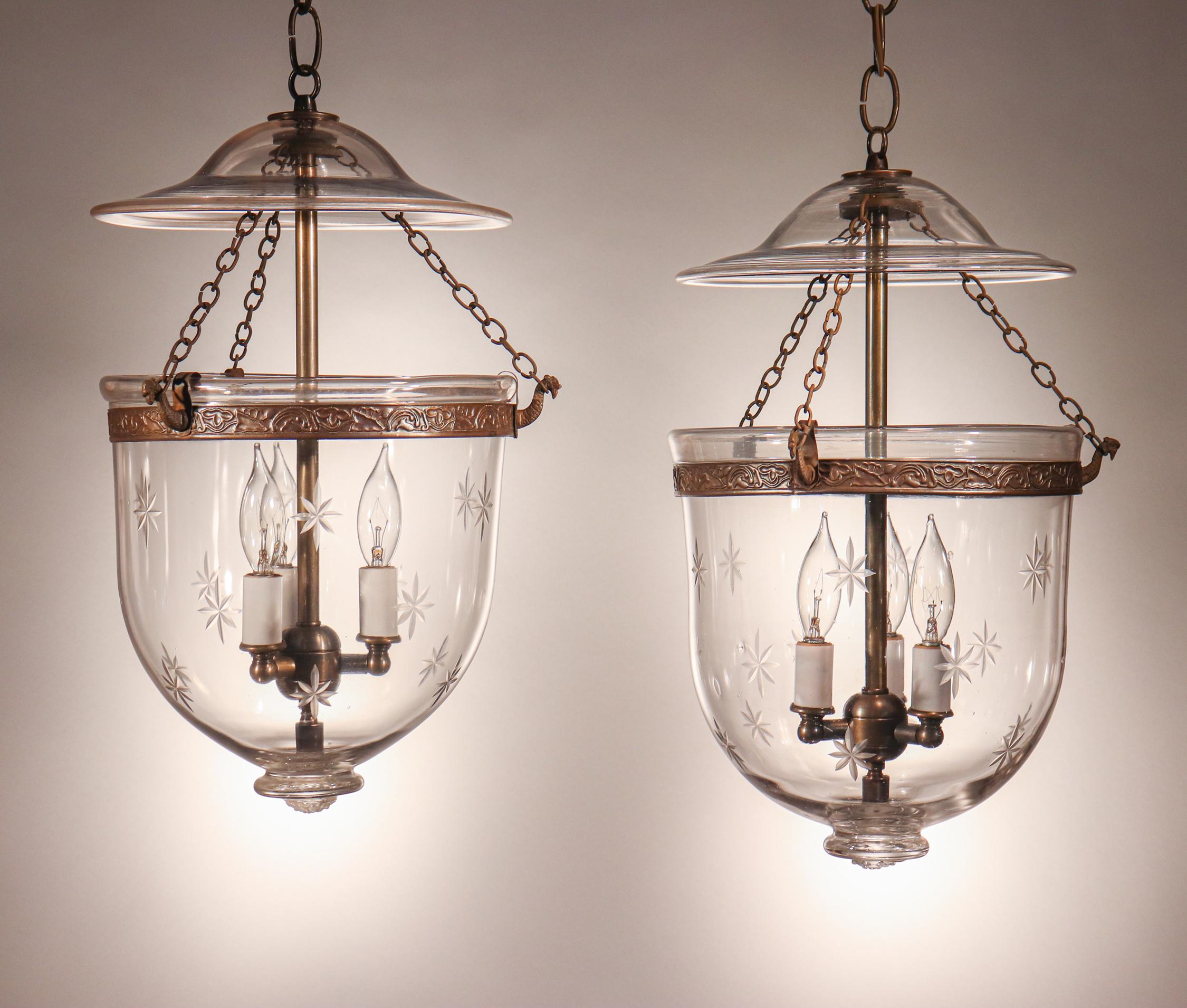 A well-matched pair of antique English bell jar lanterns with shapely form and an etched star motif. These circa 1870 pendants are of excellent quality, with desirable tiny air bubbles in the hand blown glass. The brass bands, which have an embossed