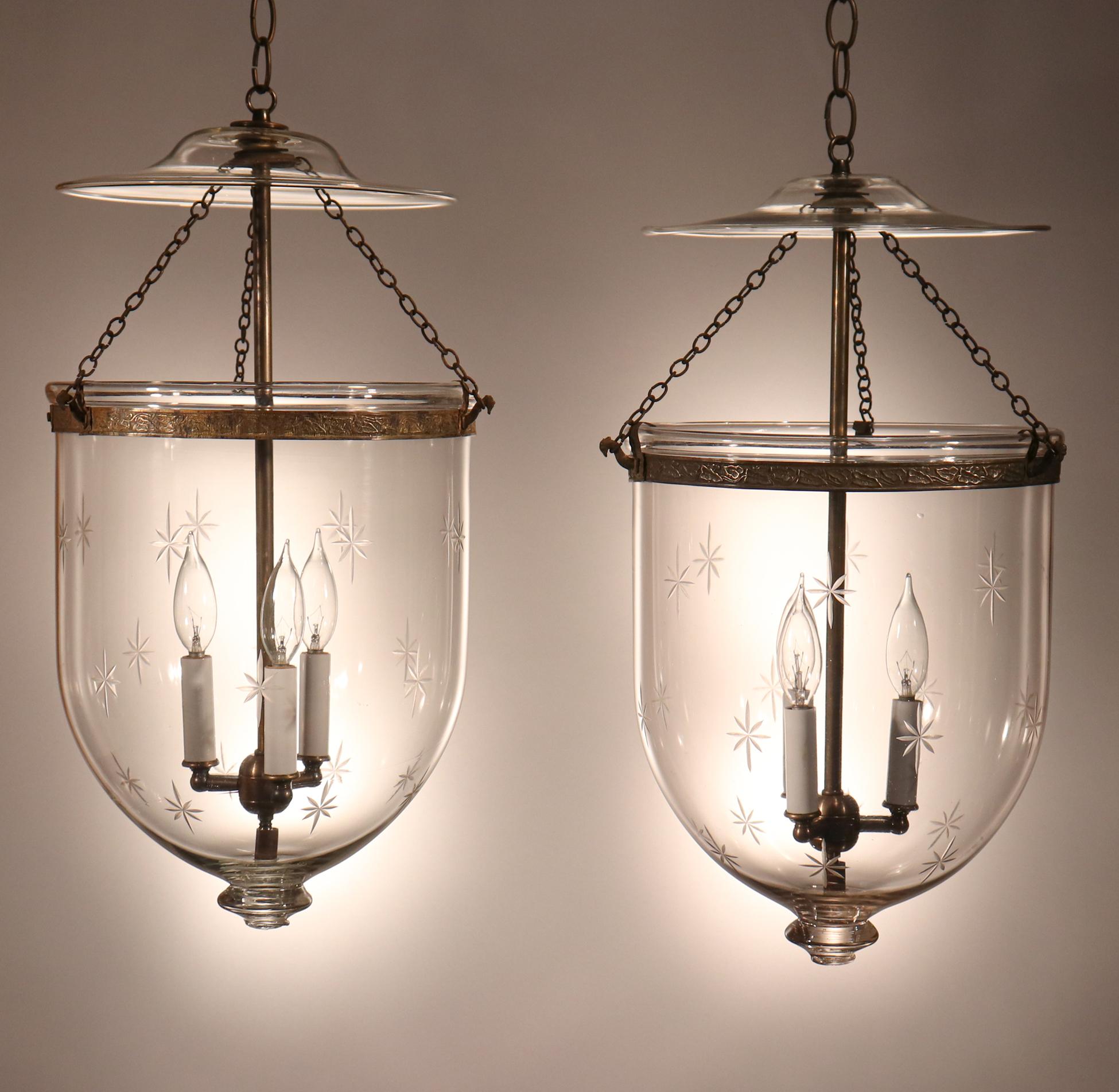 A beautiful pair of antique bell jar lanterns with a finely etched star motif. These circa 1890 lanterns, which were manufactured by S&C Bishop England, feature excellent quality hand blown glass as well as period embossed brass bands.