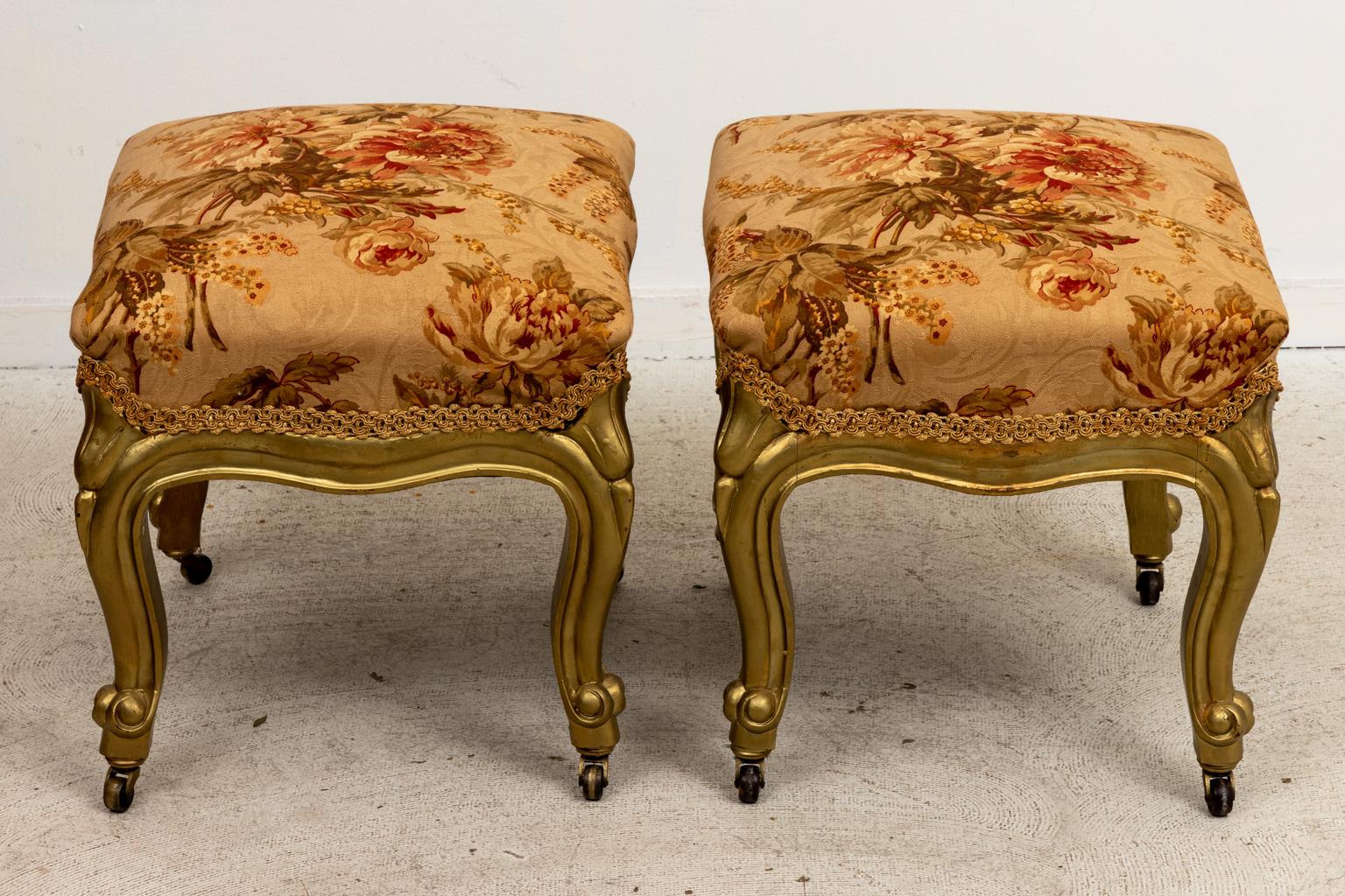 Circa 1900-1920s pair of antique benches on casters with floral upholstery and cabriole legs. Made in the United States. Please note of wear consistent with age including slight finish loss due to age and use. The chairs also have been reupholstered