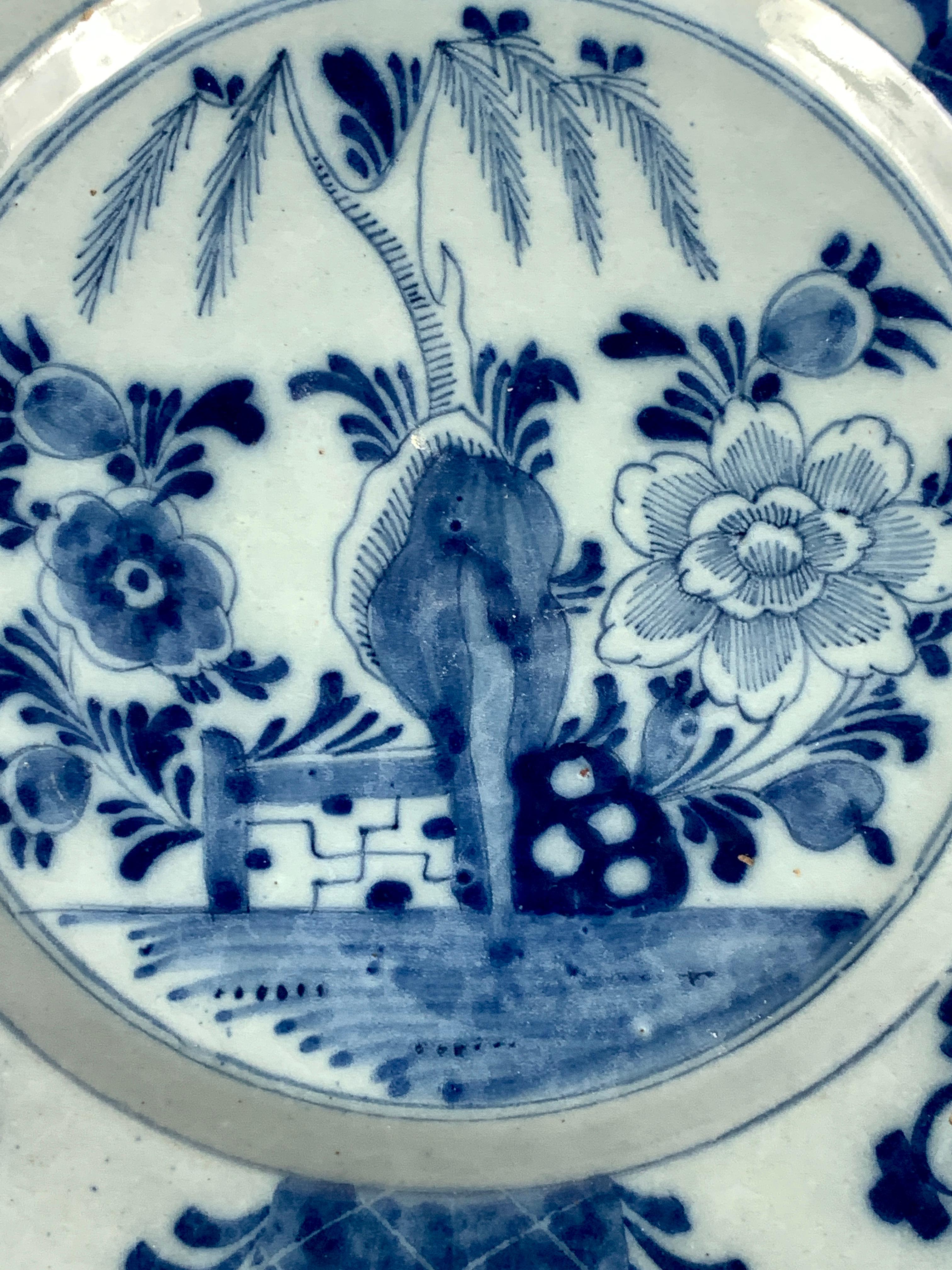 This pair of antique blue and white Dutch Delft hand-painted dishes were made circa 1770.
They feature a garden scene showing oversized flowers and a border with flowering vines and a crisscross design on a blue ground.
Dimensions: 8.65