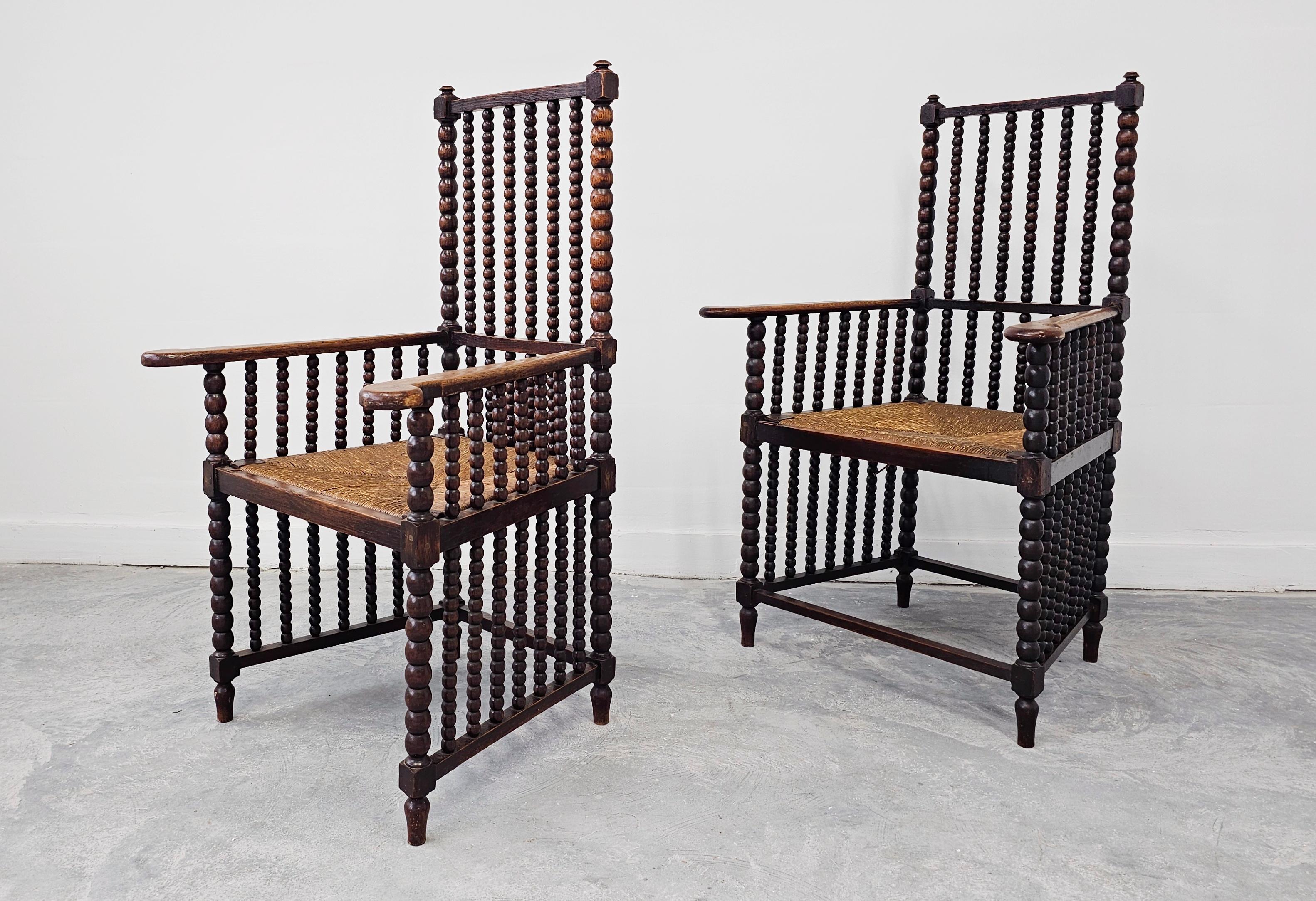 Dans cette annonce, vous trouverez une paire de magnifiques fauteuils Bobbin anciens. Leur forme trônante et très sculpturale sera un ajout saisissant dans n'importe quel intérieur. Les chaises sont en chêne massif, avec des sièges en jonc. Fabriqué