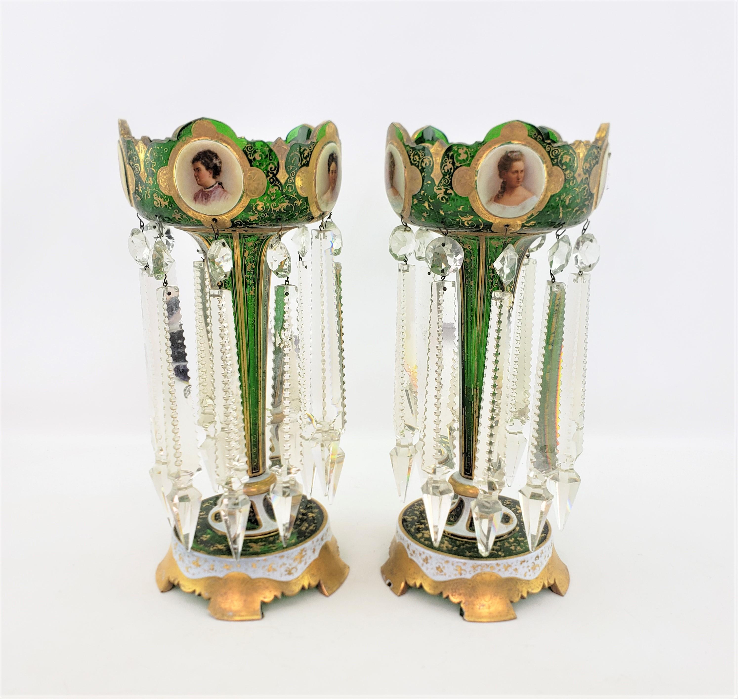 This pair of antique pedestal vases or lusters are unsigned, but presumed to have originated from the Czech Republic and date to approximately 1880 and done in the period Victorian style. The lusters are done with a deep green cut crystal with