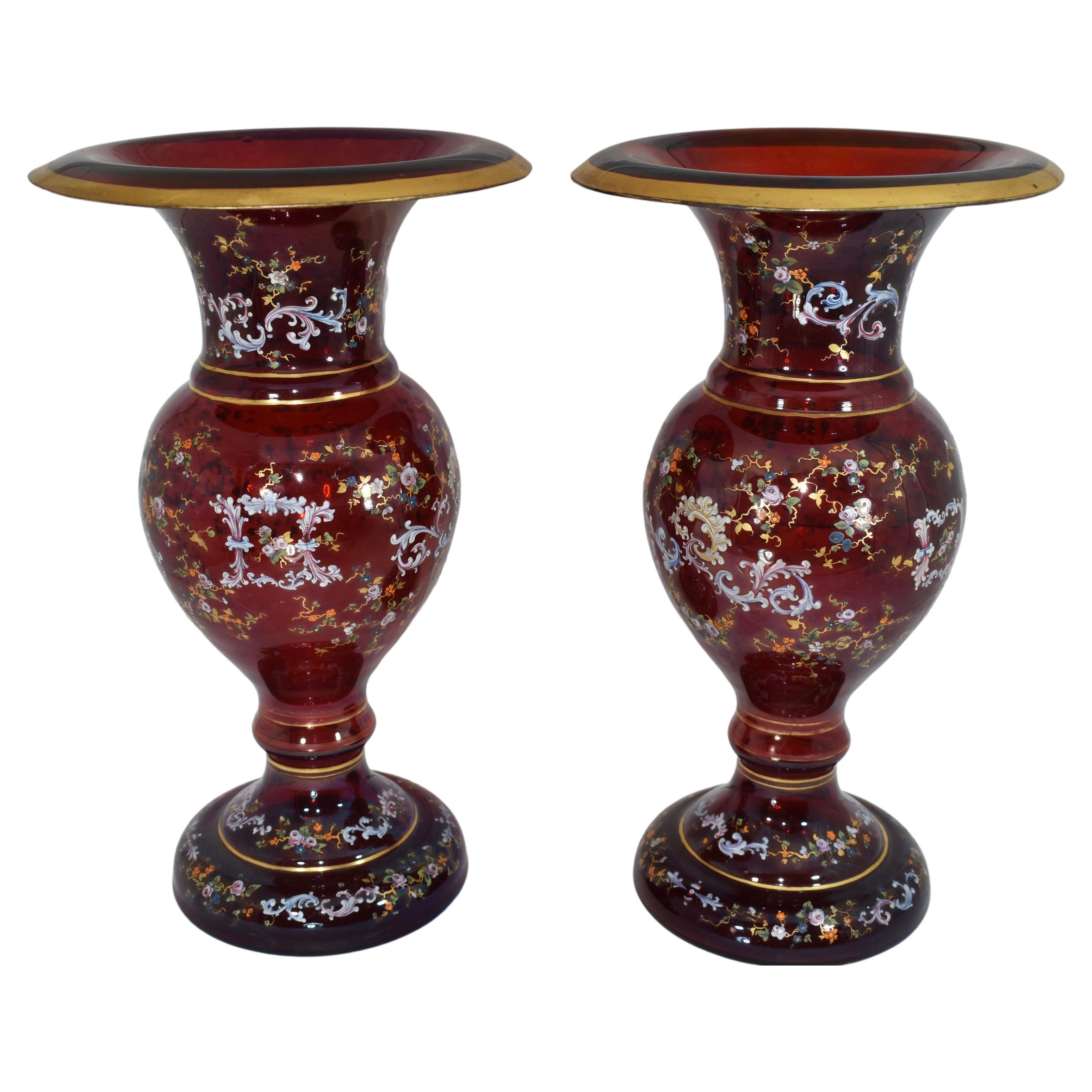 Grands vases Moser en verre rouge rubis, corps circulaire richement décoré tout autour d'une délicate dorure à l'émail, peint à la main avec des volutes et des fleurs colorées.
Bohemia, Circa 1880