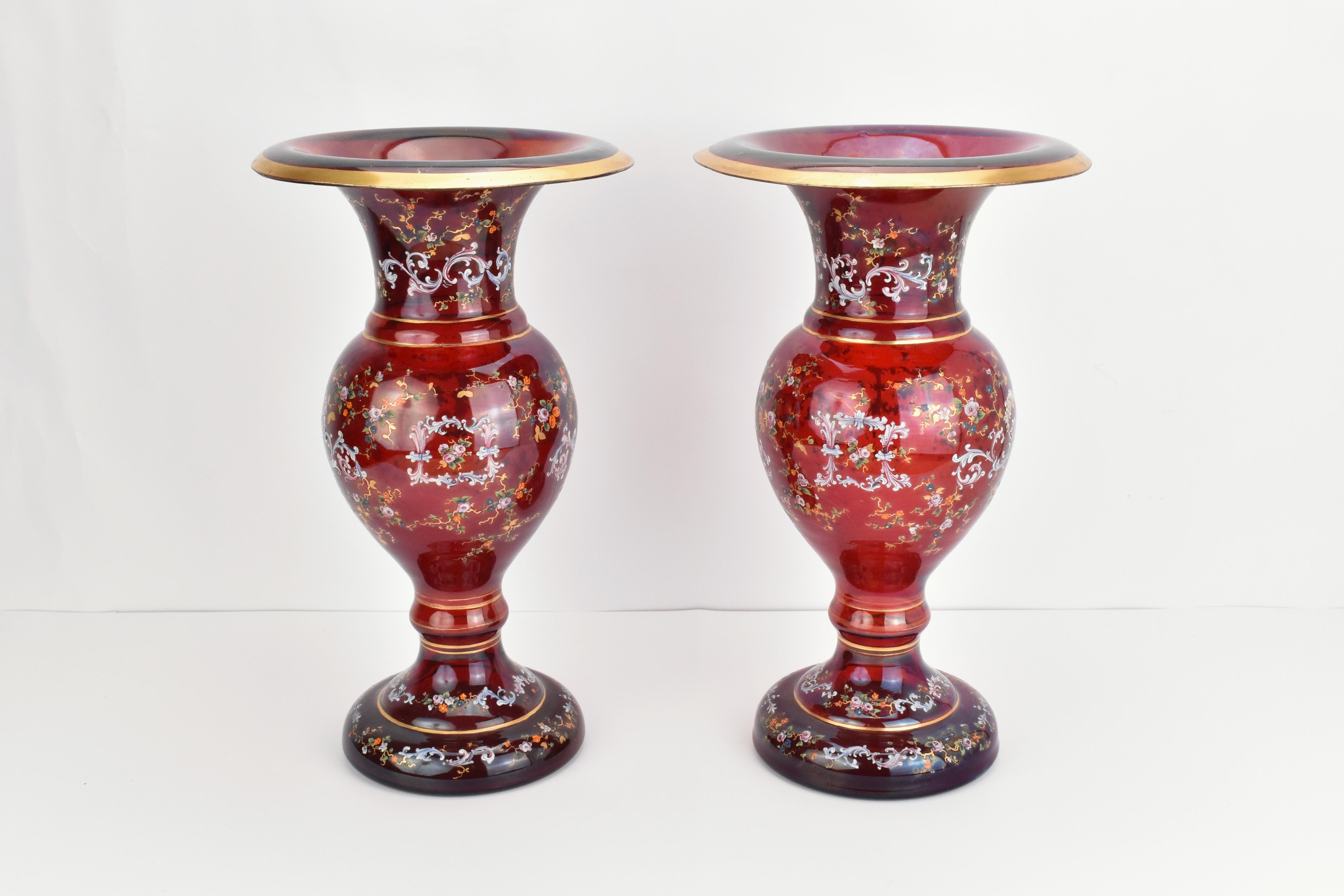 Una grande coppia di vasi in vetro di Boemia rosso rubino di Moser, realizzati in vetro artistico soffiato a mano e riccamente decorati con impressionanti disegni dipinti a mano.

I corpi circolari sono riccamente decorati con delicate smaltature,