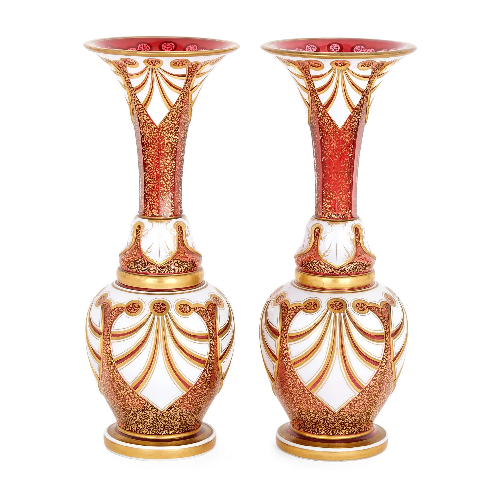 Pair of antique Bohemian ruby glass and parcel gilt vases 
Bohemian, Late 19th Century 
Height 38cm, diameter 14.5cm

Manufactured in Bohemia (modern-day Czech Republic), the renowned centre of glass production, this pair of vases is of baluster