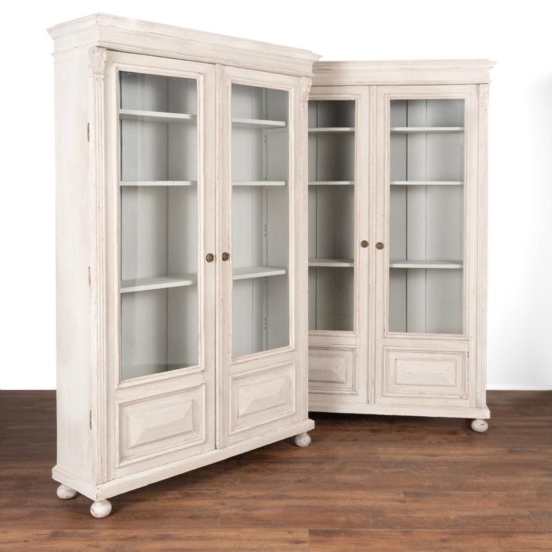 These exceptional bookcases are a tremendous find as it is difficult to find a matching pair. The professionally applied (newer) light gray and white layered paint is perfectly distressed to fit with the age and character of the pair leaving an