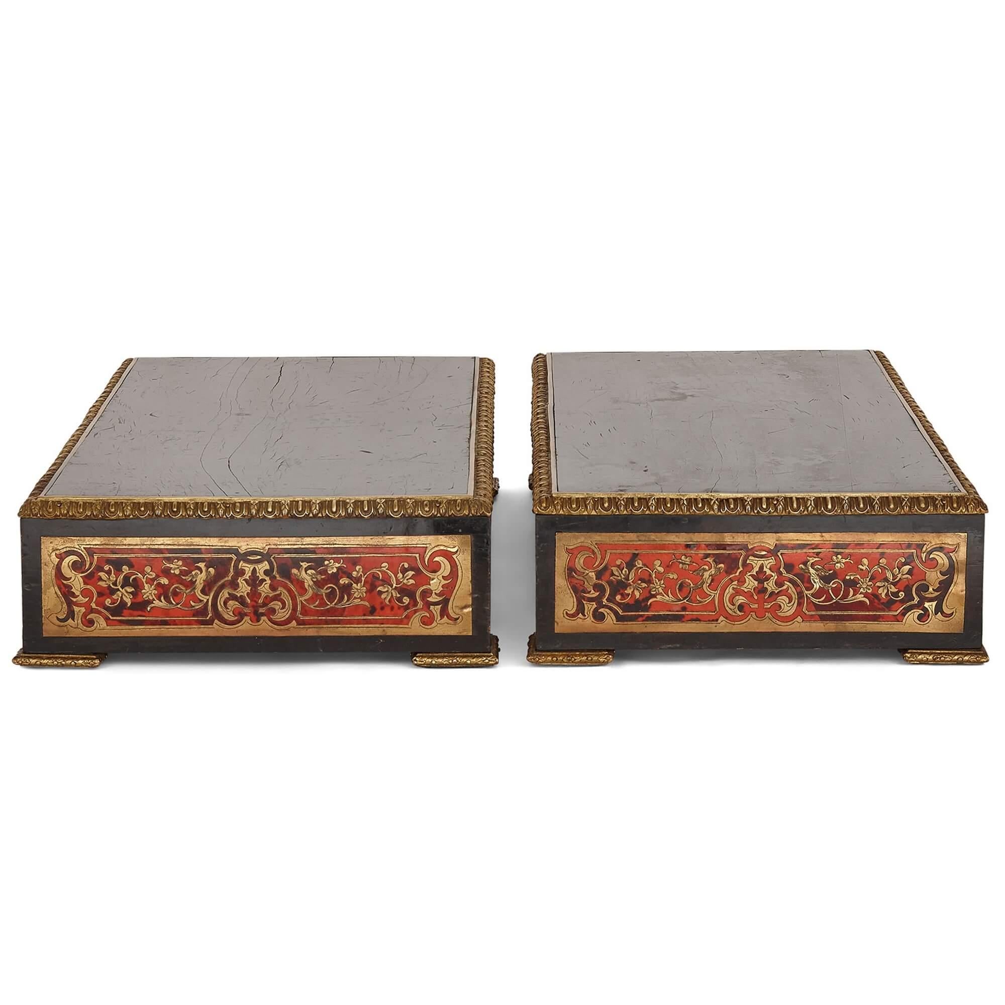 Pair of antique Boullework brass marquetry stands
French, 19th Century
Measures: height 13cm, width 63cm, depth 34cm

The stands in this pair are crafted from ebonised wood mounted with gilt bronze. The sides of each stand feature panels of