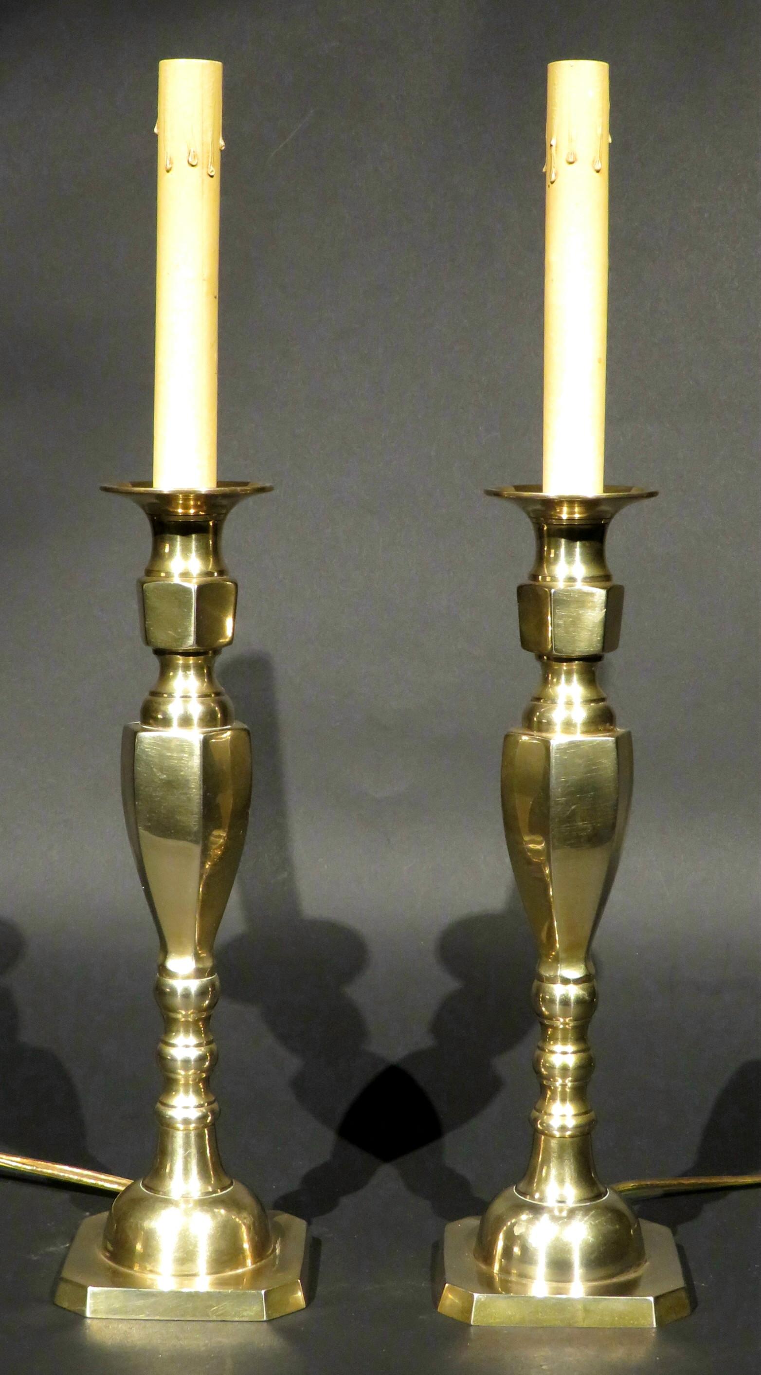 Both showing faceted columns rising to conforming nozzles, raised overall upon squared bases with canted corners. Fitted with complimentary black paper shades with gilt lined interiors.
Height, 17