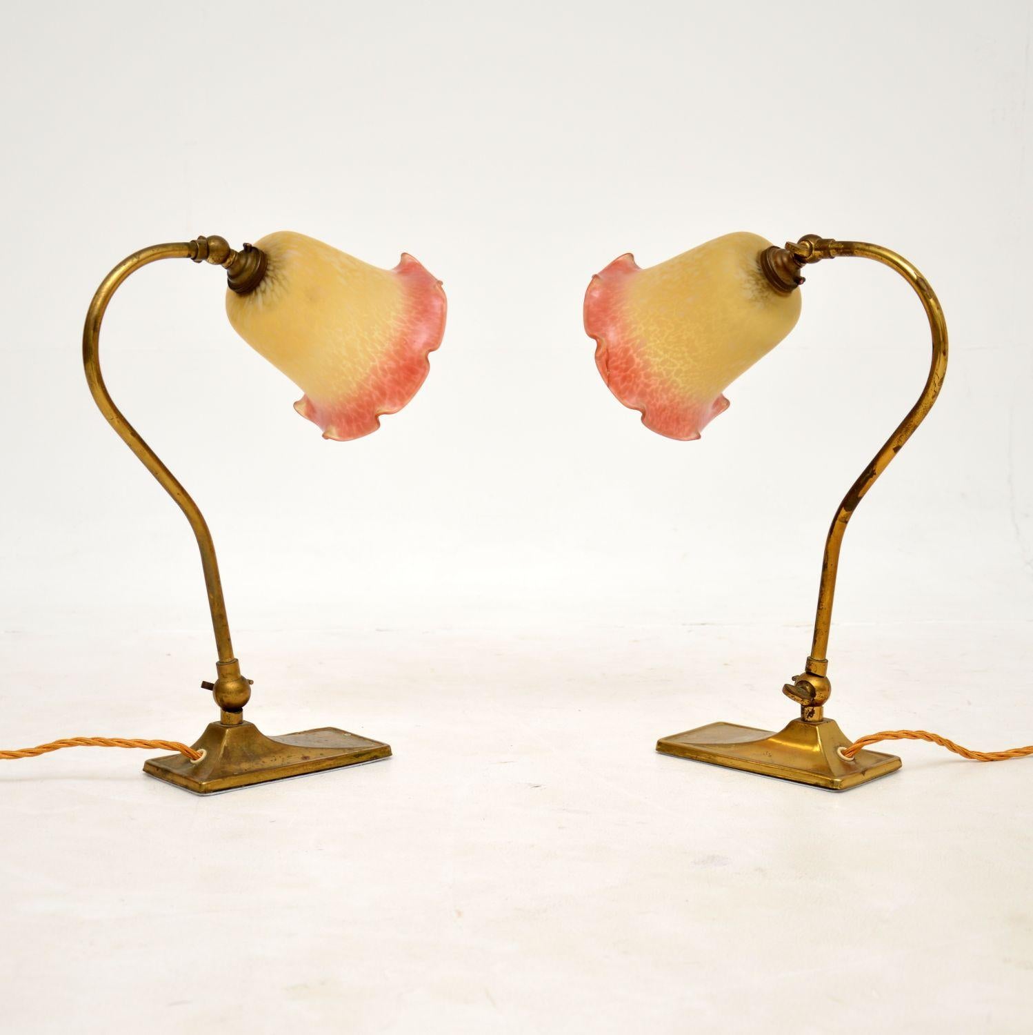 A gorgeous pair of antique table lamps in solid brass with beautiful glass shades. They were made in England and date from around the 1920s.

They are of superb quality and are a lovely size. They are adjustable at the bases and neck, they can be