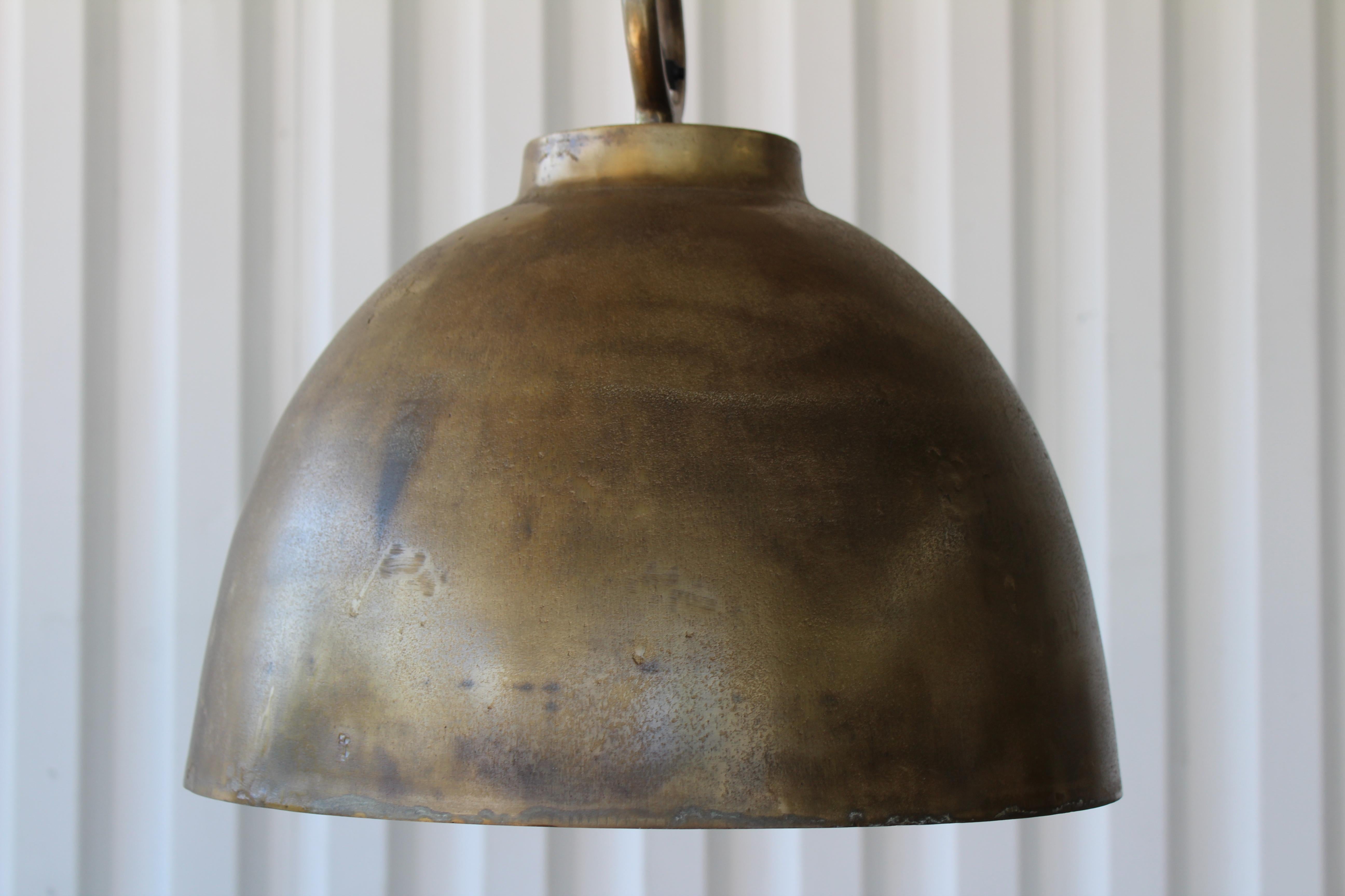 Steel hanging pendant in an antique brass finish. Newer production. Two available, each sold individually. The light fixture itself is 61 inches total height from top of canopy to bottom of the pendant. The pendant alone is 13 inches high with a