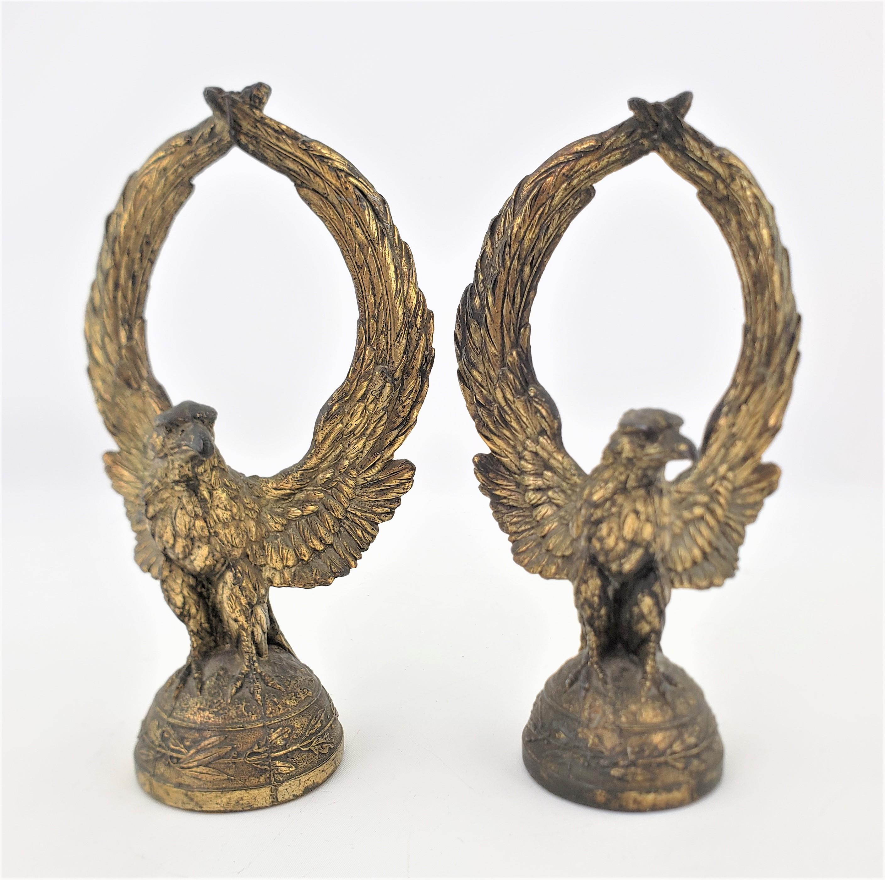 This matched pair of antique figural Bald Eagles are unsigned, but presumed to have been made in the United States in approximately 1900 in an Edwardian style. The eagles are cast in a very realistic and detailed manner in a spelter or base metal,