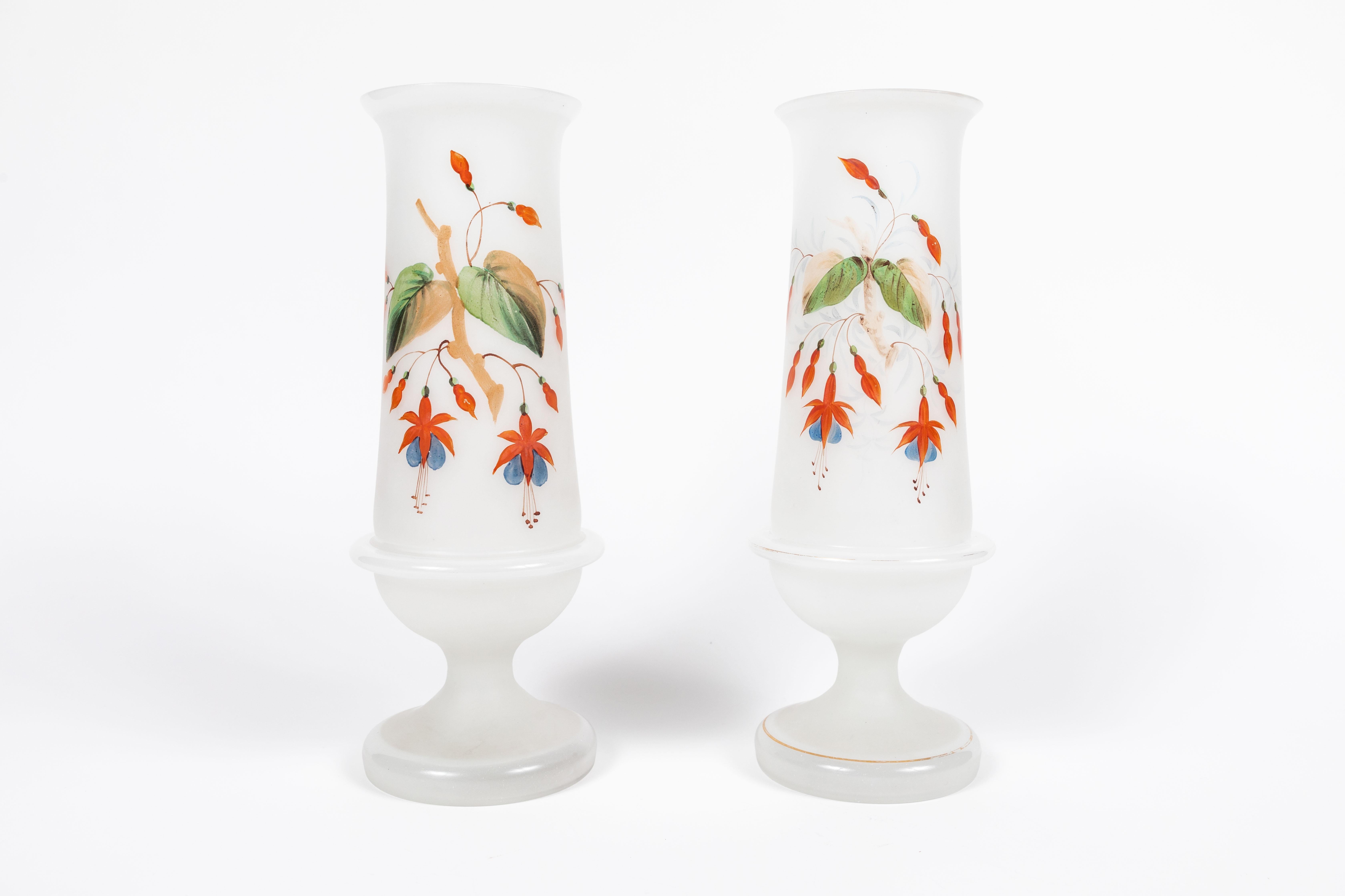 Here is a stunning pair of antique Bristol hand painted footed frosted glass vases. They are decorated with detailed fuchsias and a vine with detailed large leaves. A gorgeous addition to a mantel or shelf. They each measure 5
