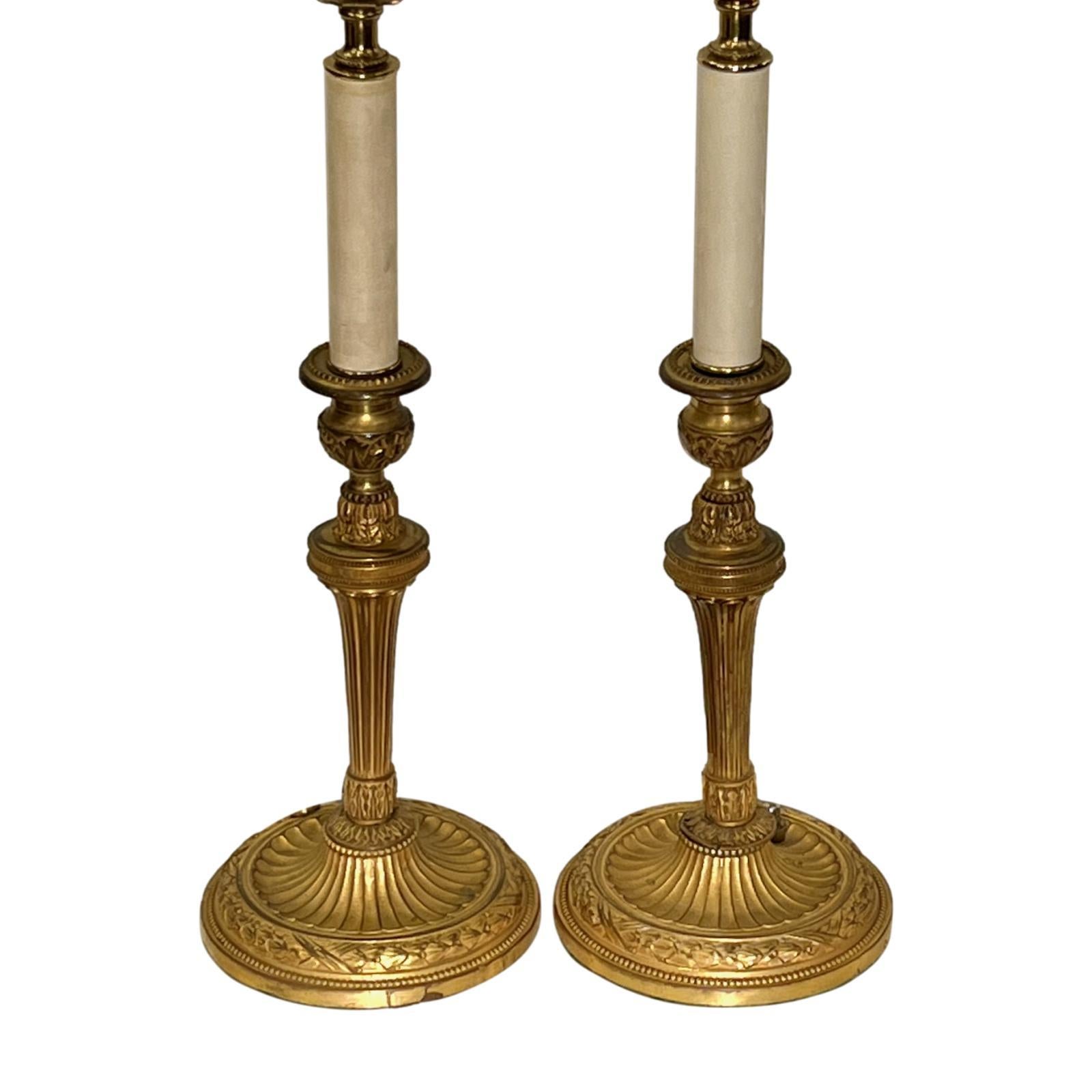 A pair of circa 1920's French bronze candlestick table lamps.

Measurements:
Height of body: 15