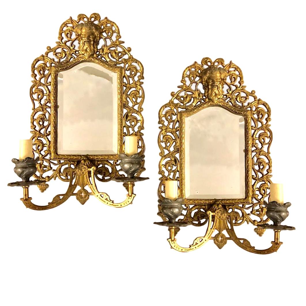 Pair of circa 1900 French bronze mirror-backed sconces with scrolling foliage open-work motif and Bacchus mask atop.

Measurements:
Height: 16